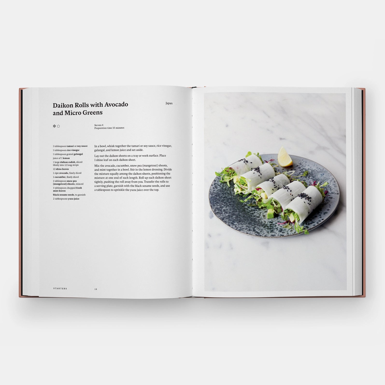 Open cookbook showing a recipe for Daikon Rolls with Avocado and Micro Greens on a marble surface.