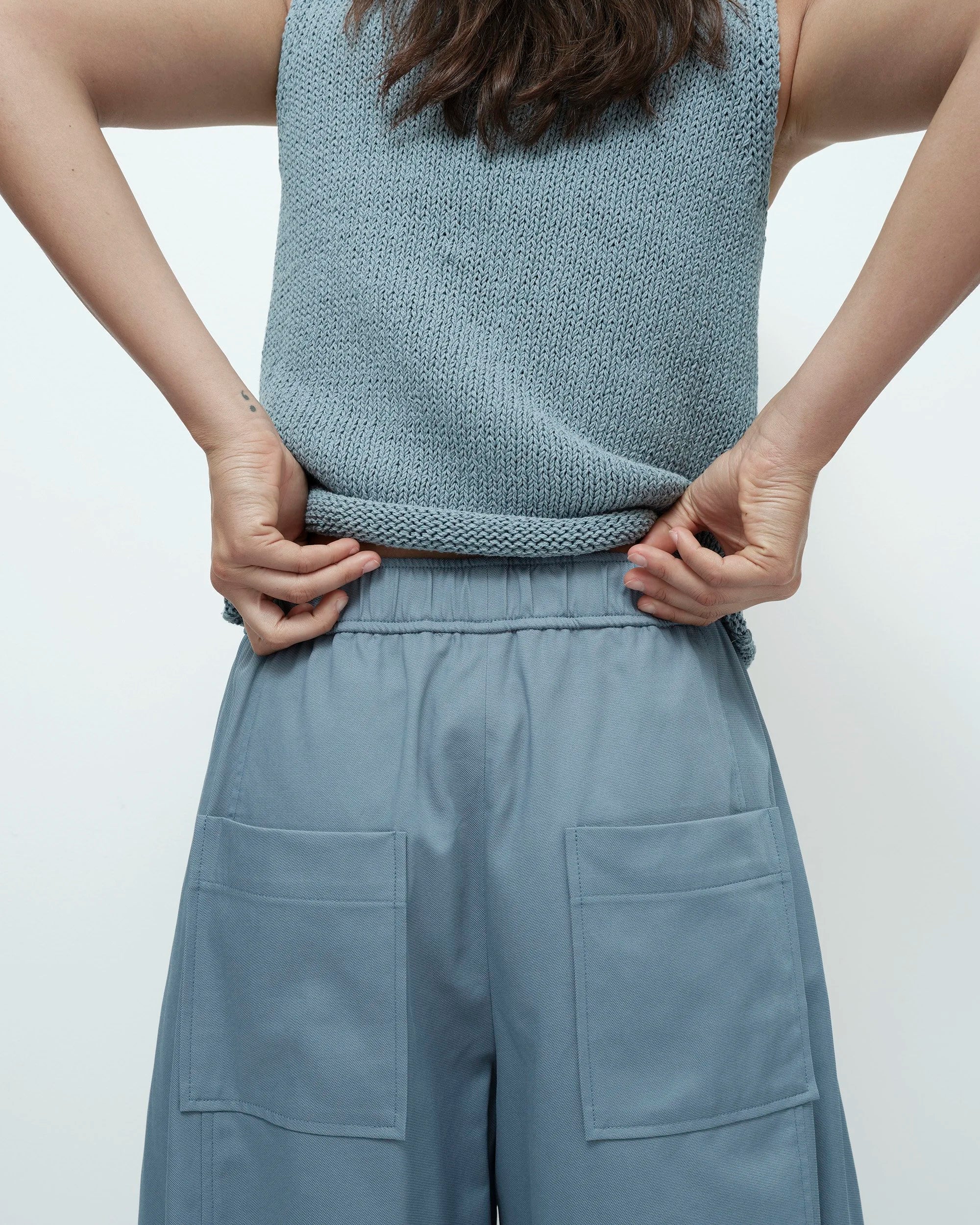 Person wearing a matching sleeveless top and wide-leg pants in a light blue color on a plain background