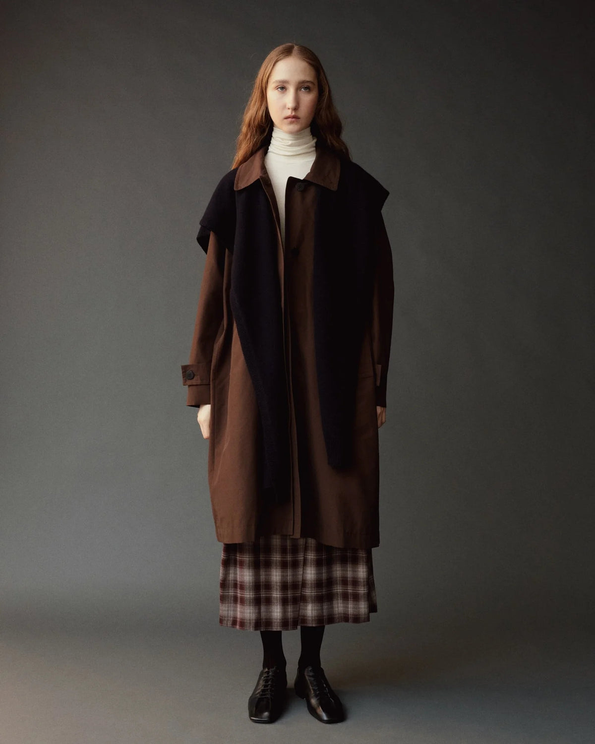 person modeling long brown trench coat with black shawl 