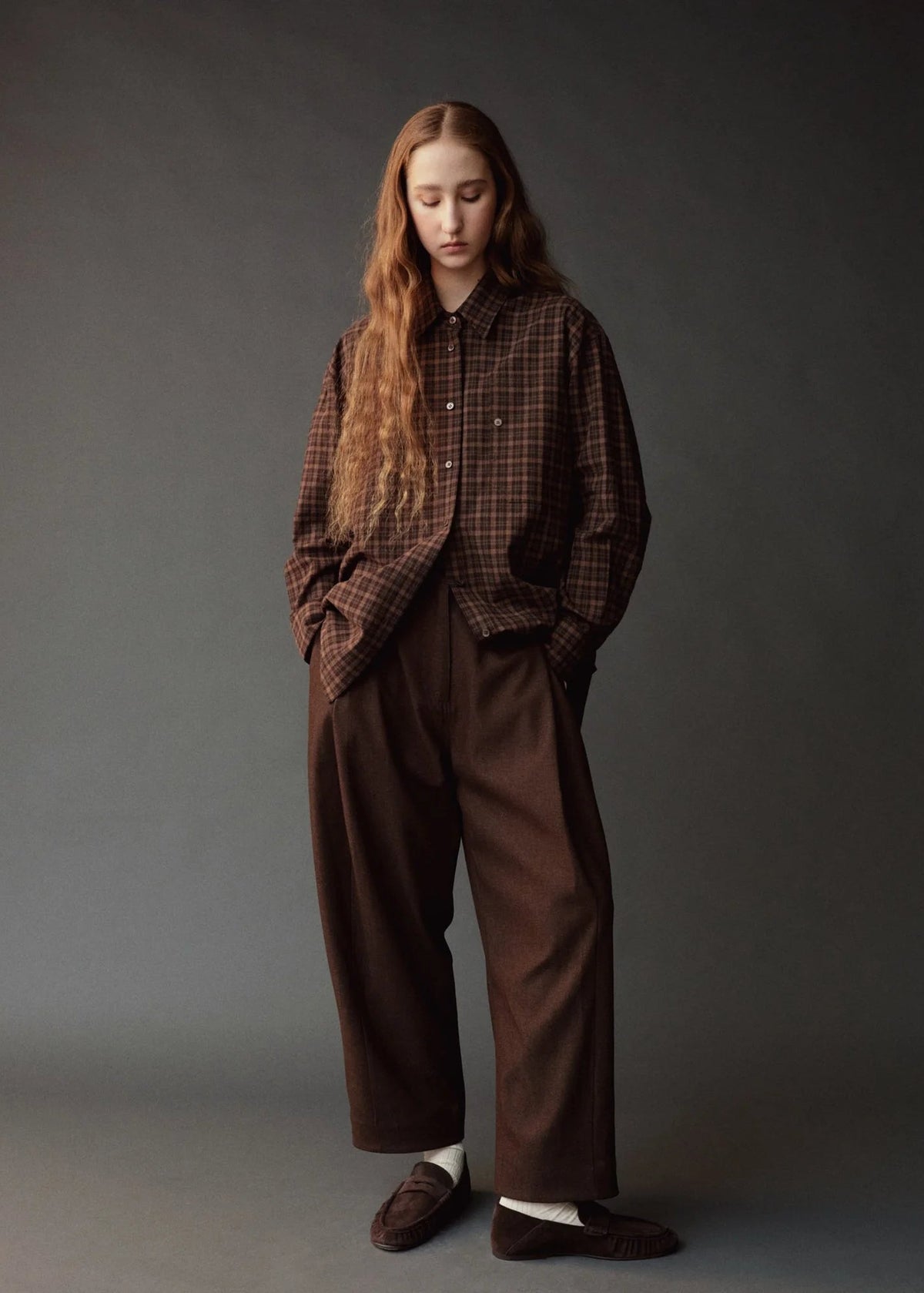 model wearing brown pants and brown plaid shirt