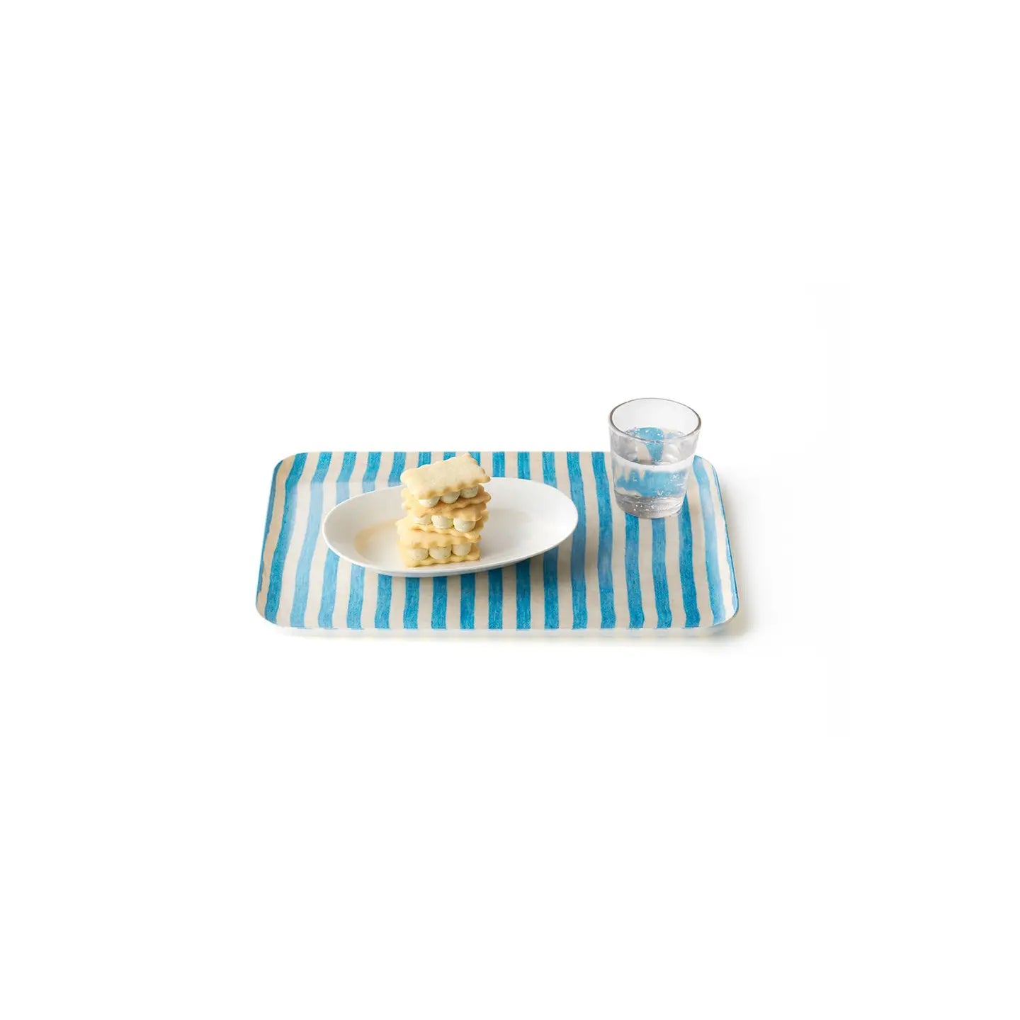 Blue and white striped tray with a plate of cookies and a glass on a white background