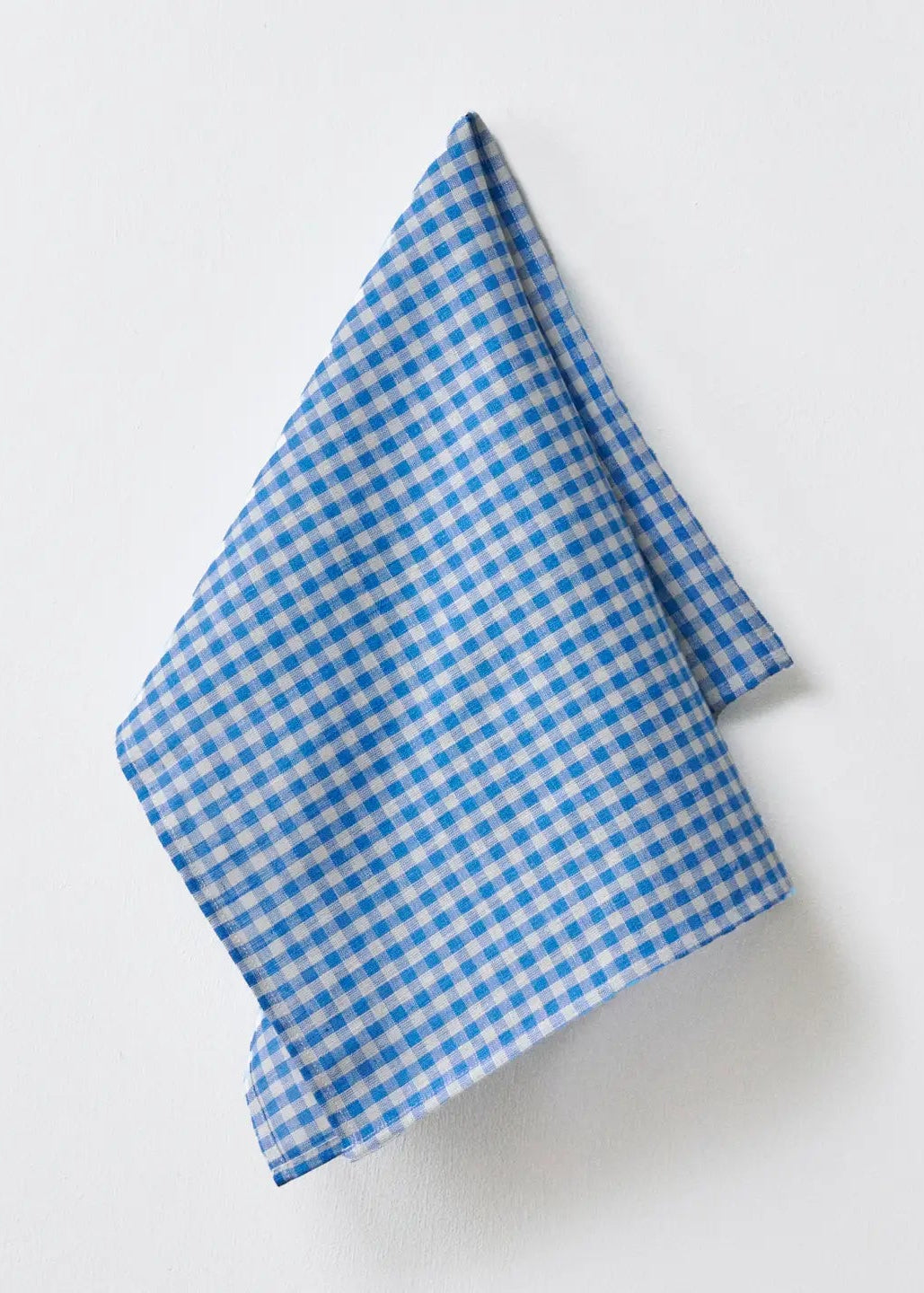 A folded blue and white gingham checkered cloth napkin or pocket square, displayed on a clean white background.