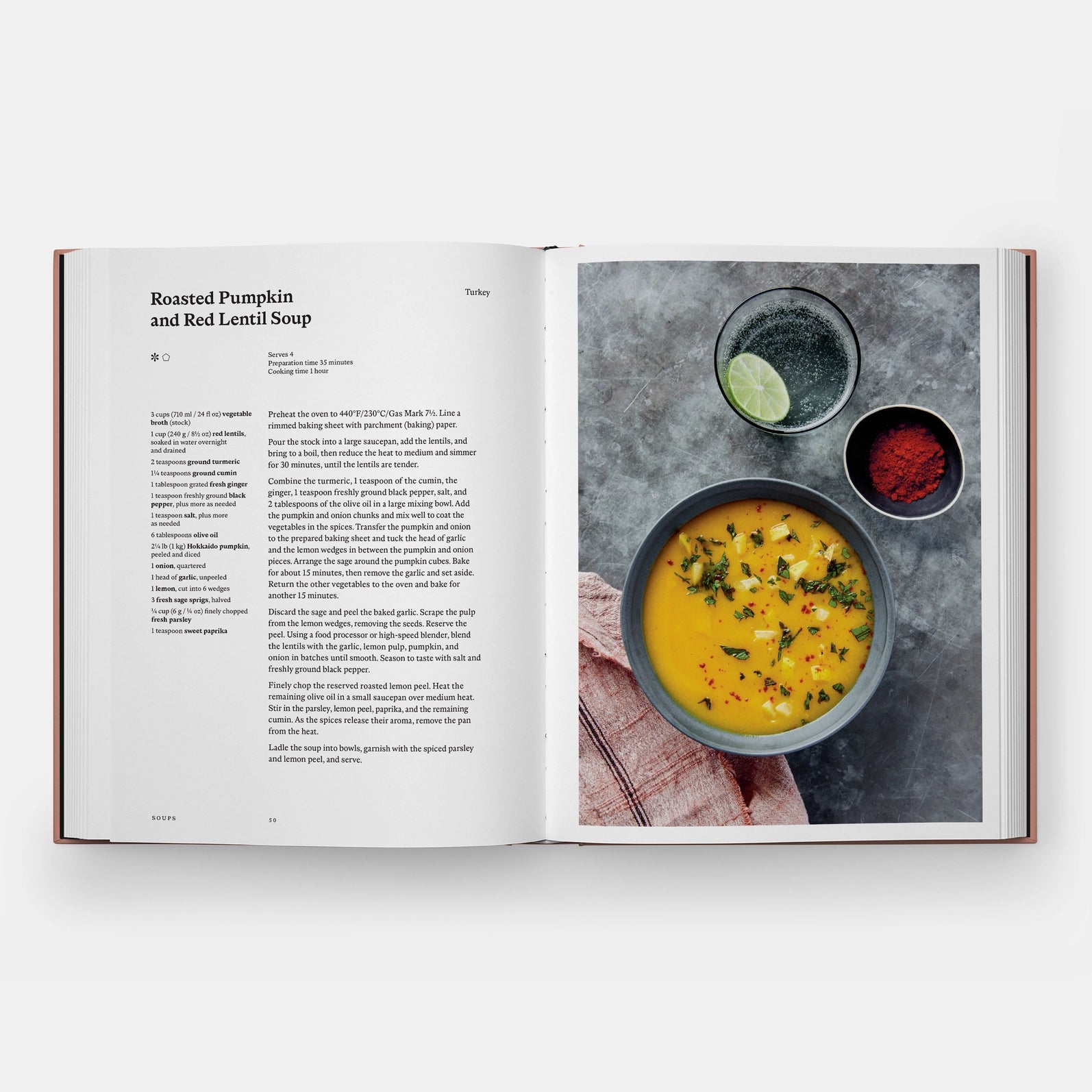 Open cookbook showing a recipe for roasted pumpkin and red lentil soup with a photo of the dish on a white background.