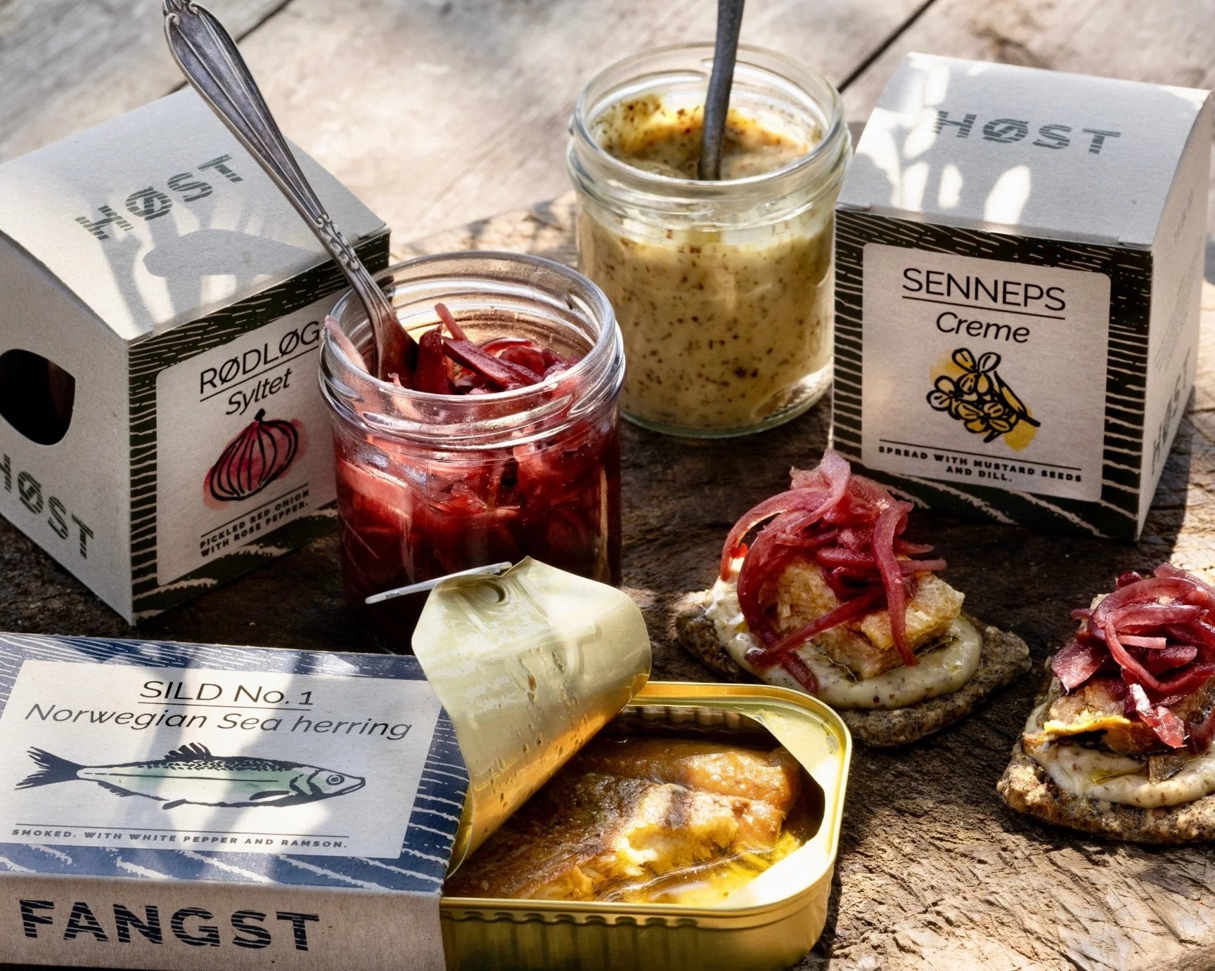 Assorted food items including jars, a can, and boxes on a wooden surface.
