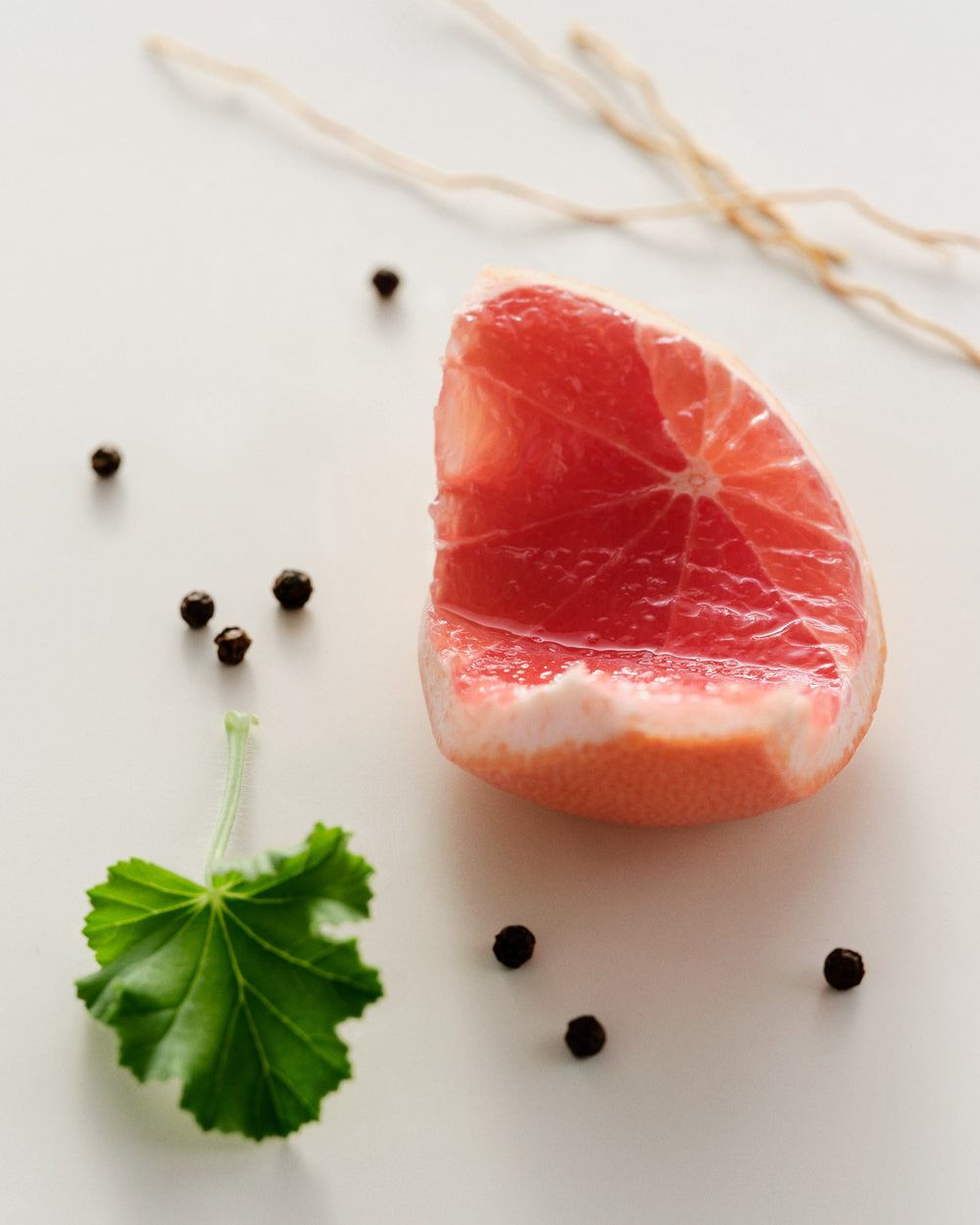 grapefruit, peppercorns and a leaf