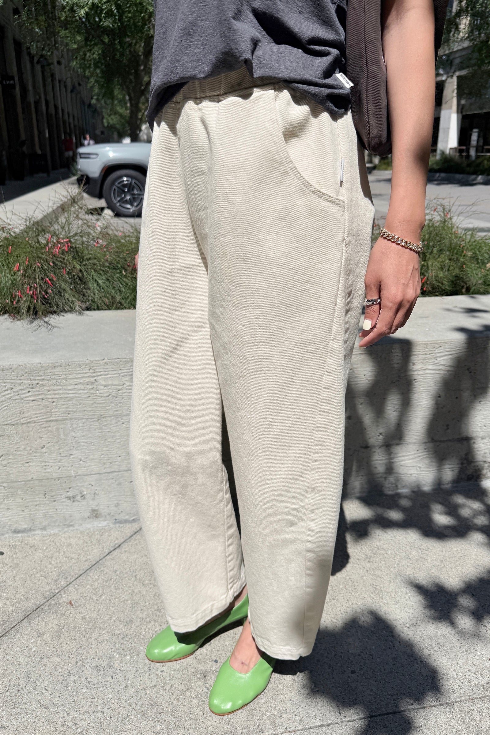 Person wearing beige wide-leg pants on a sidewalk.