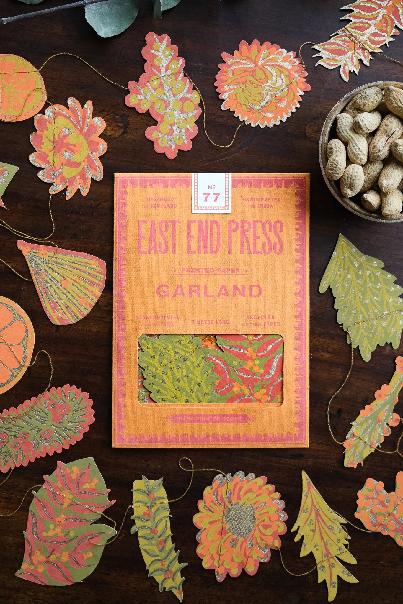 Packaged Garland with colorful leaf designs on a wooden surface