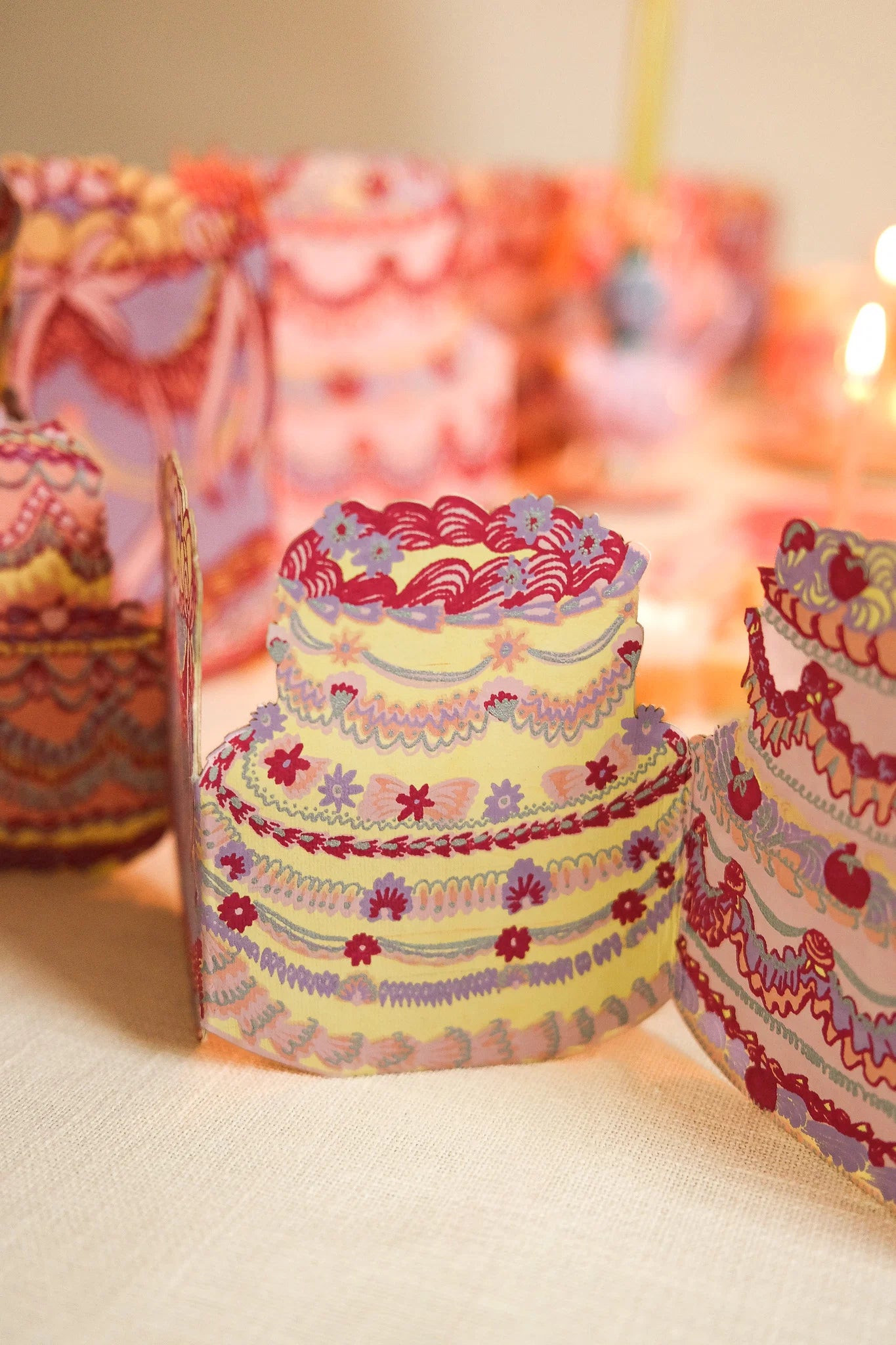 Colorful paper cake models on a neutral background