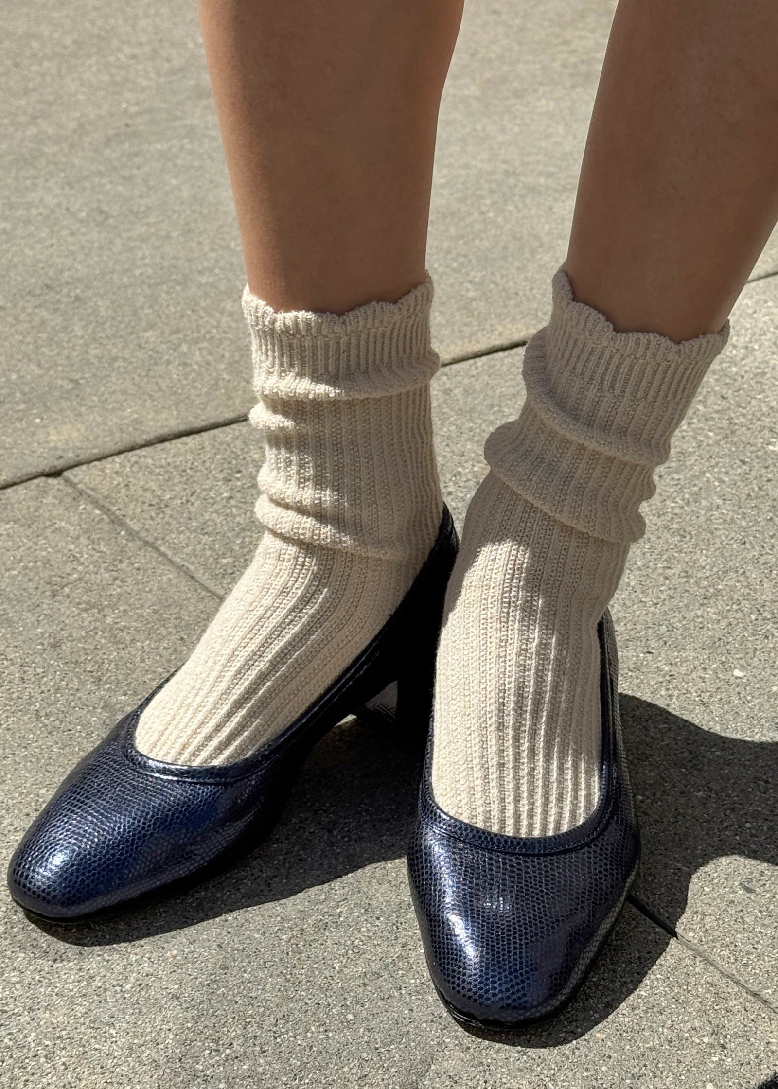 Navy blue shoes with white socks on a concrete surface
