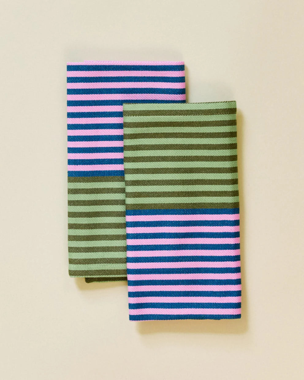 Two striped napkins one green and pink, the other blue and pink, on a beige background.