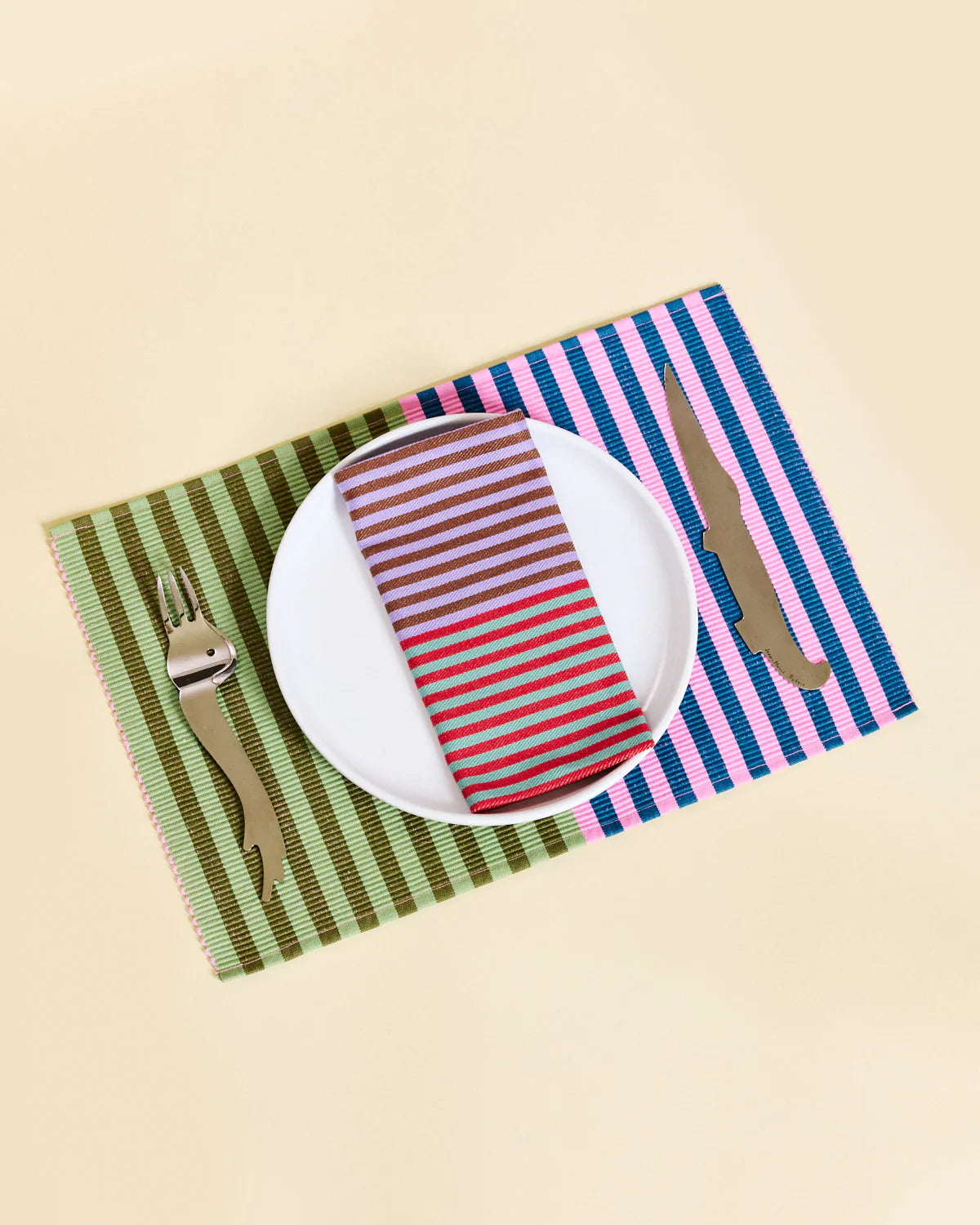 Placemat with cutlery design featuring a plate, striped napkin, and cutlery on a beige background