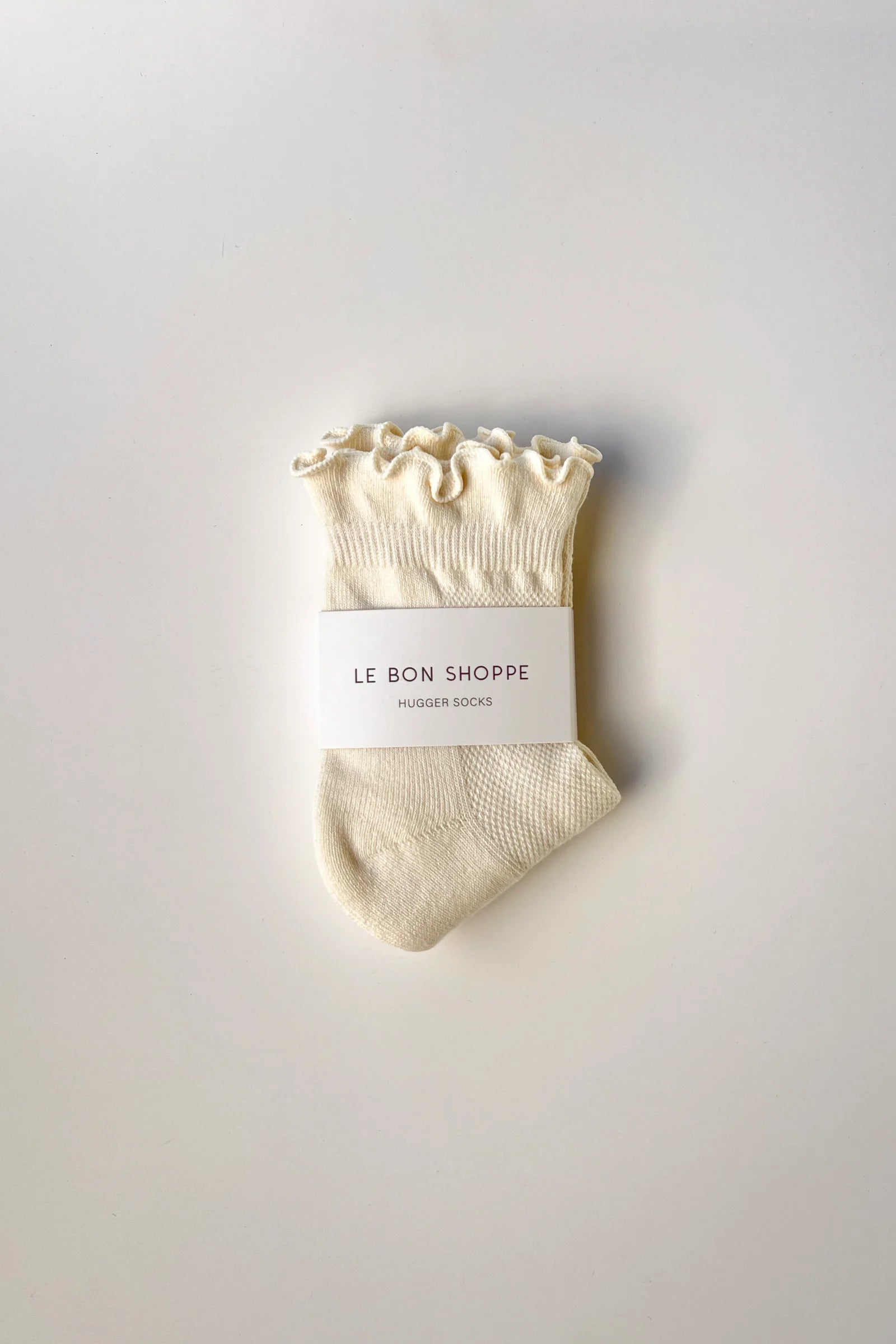 Beige sock with ruffled top on a white background, featuring 'Le Bon Shoppe' branding.