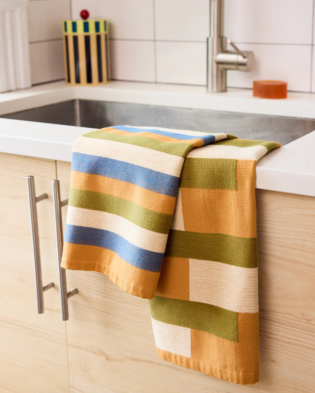 Colorful striped towel hanging on a kitchen sink
