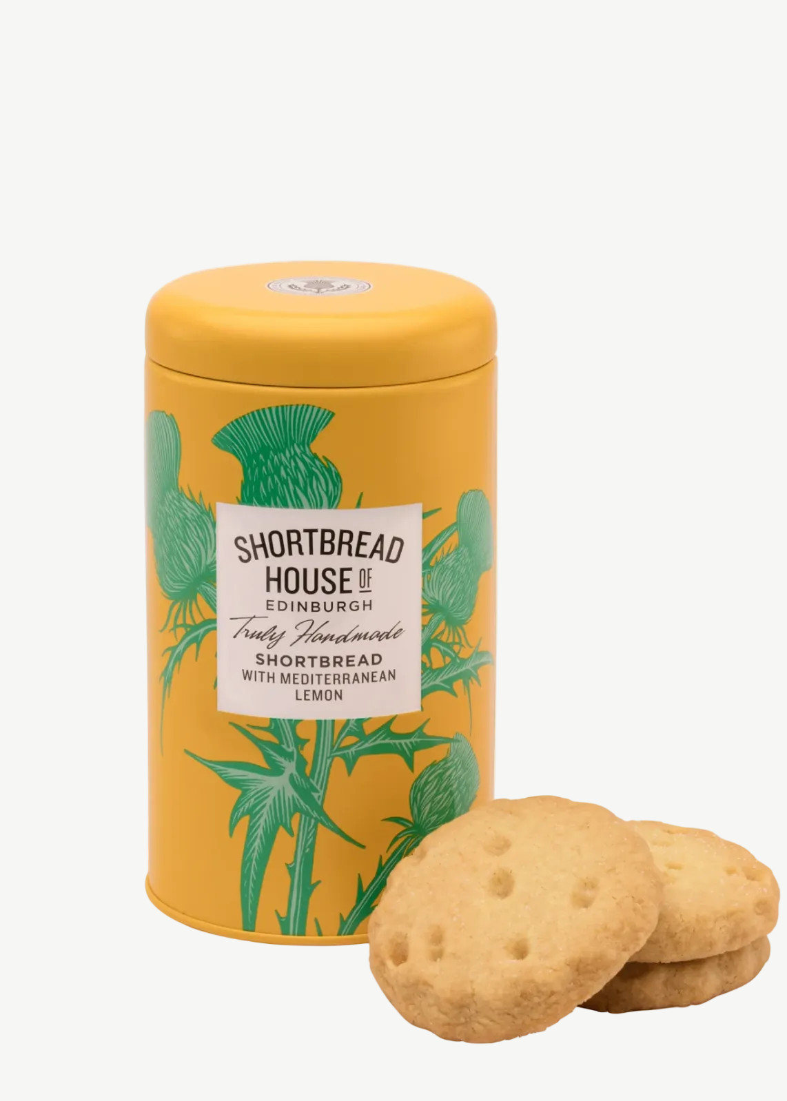 Yellow tin canister with green botanical design and a shortbread cookie on a white background