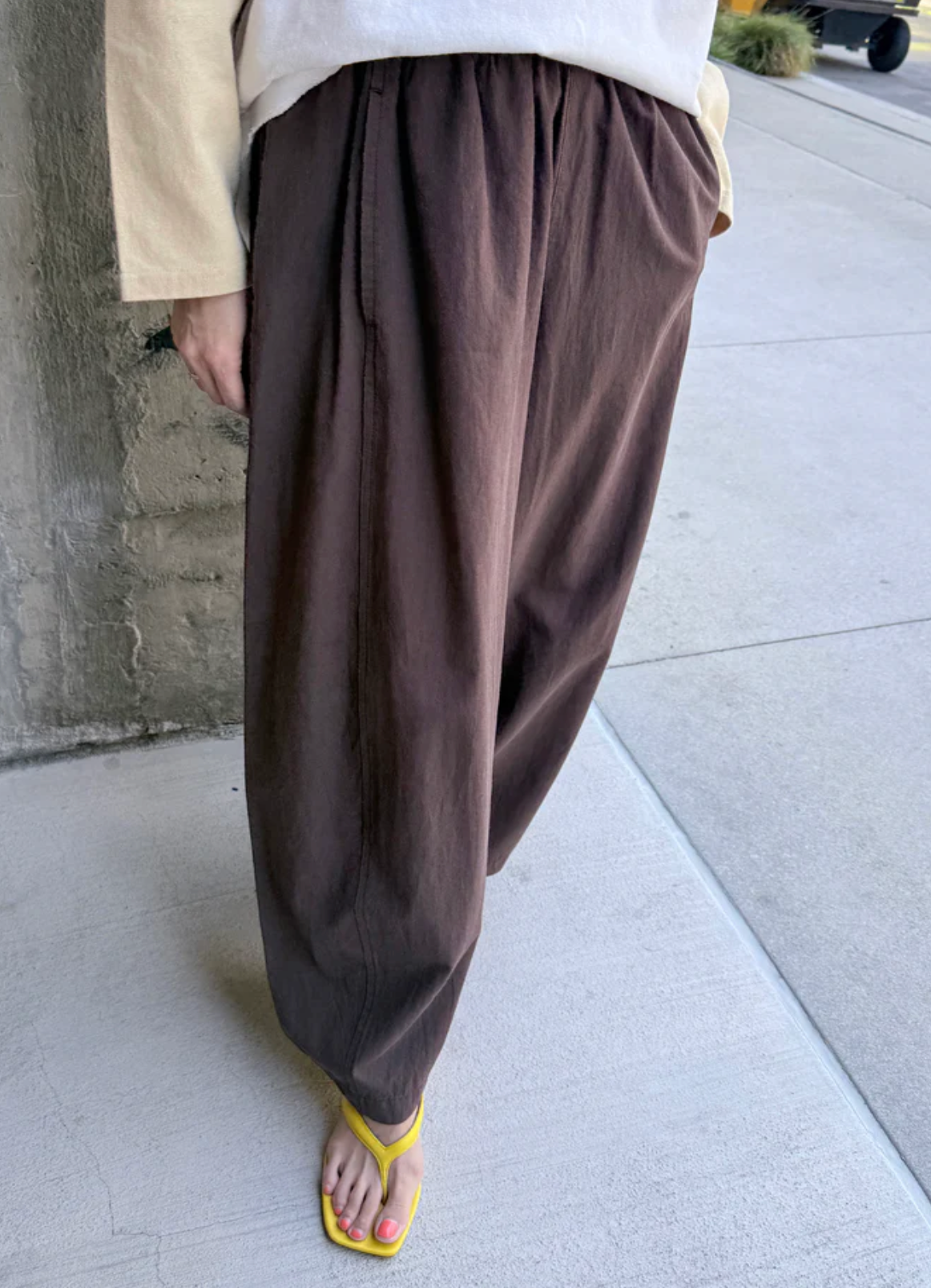 Brown wide-leg pants worn by a person on a concrete surface.