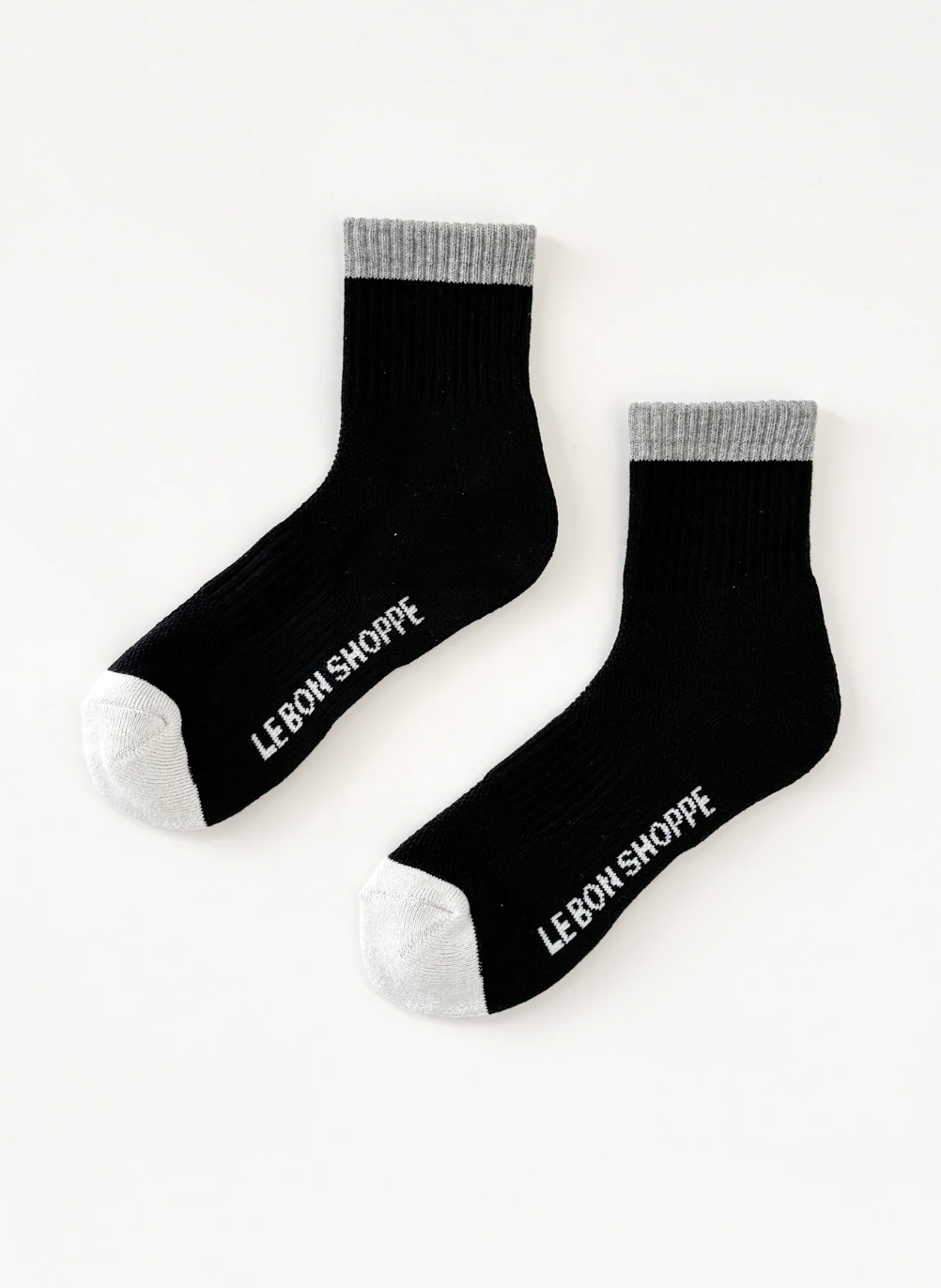 Black socks with white text 'LE-BON SHOPPE' on a white background