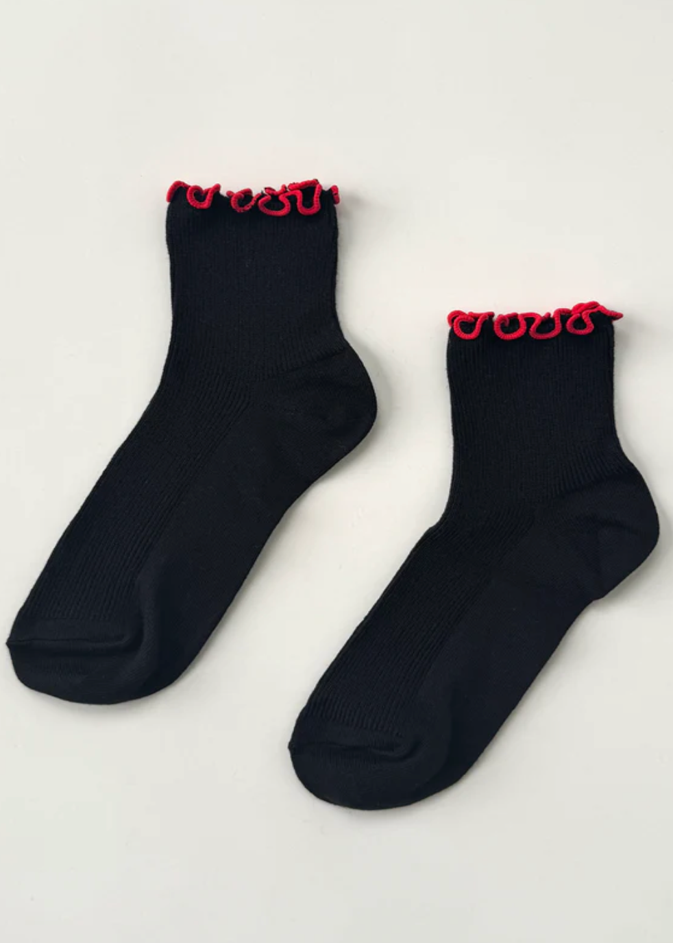 Black socks with red trim on a light gray background