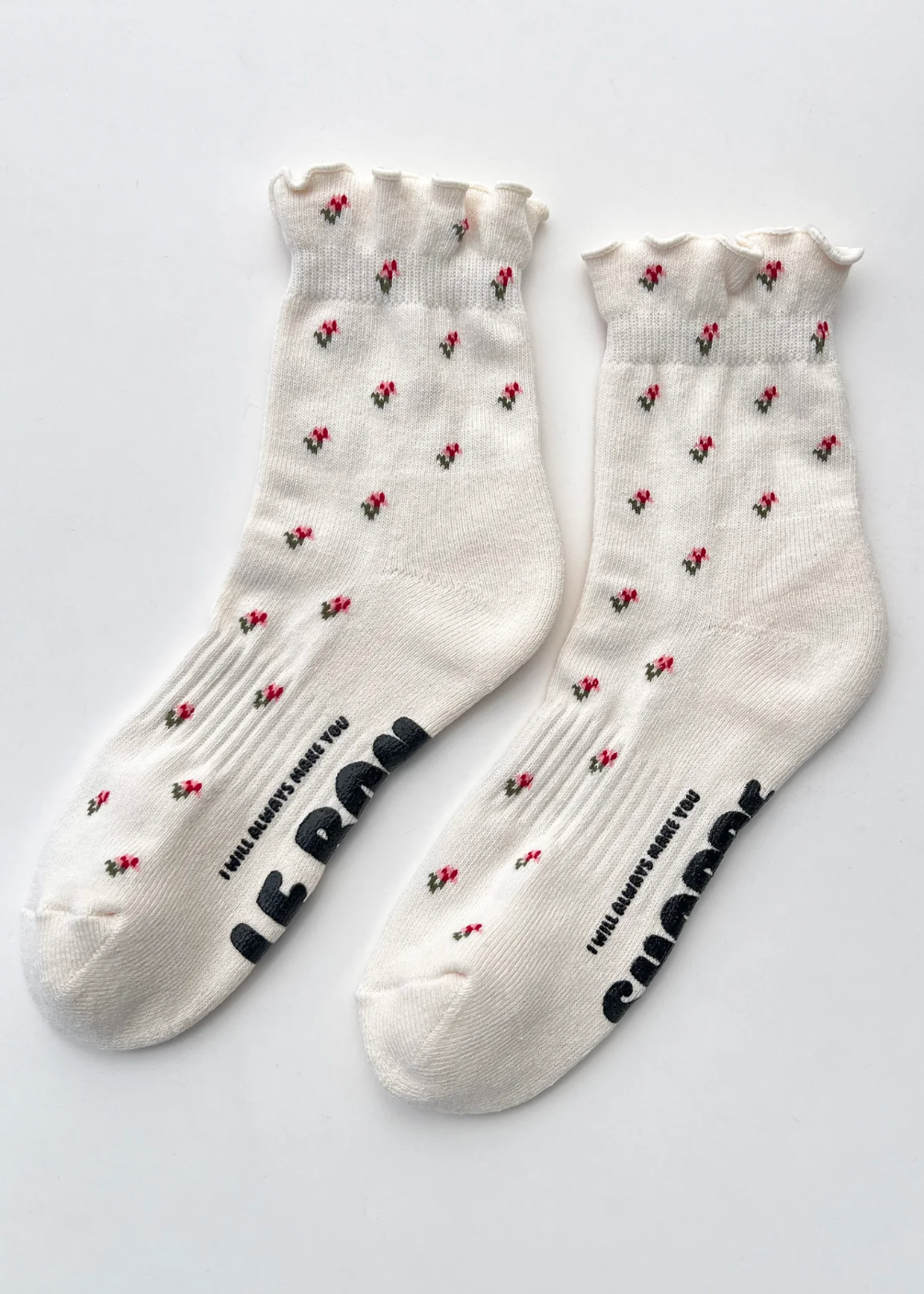 White socks with black text and red floral patterns on a light gray background
