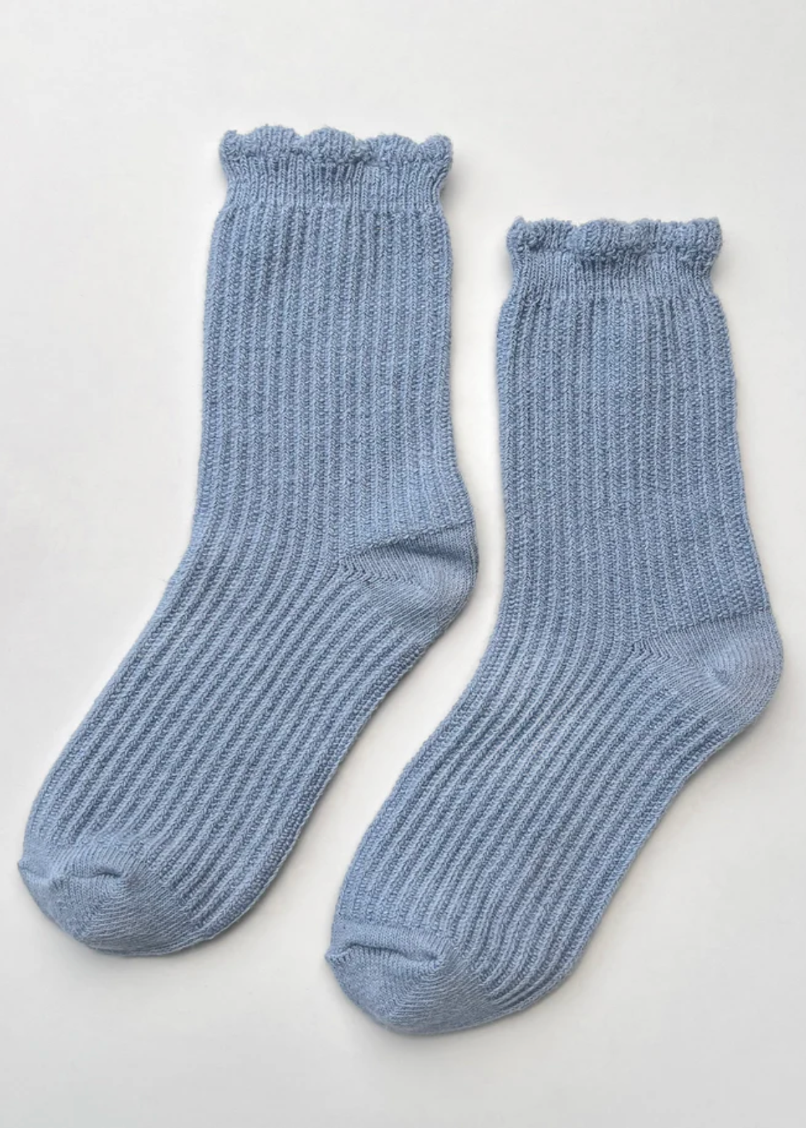 Pair of blue socks on a light gray background