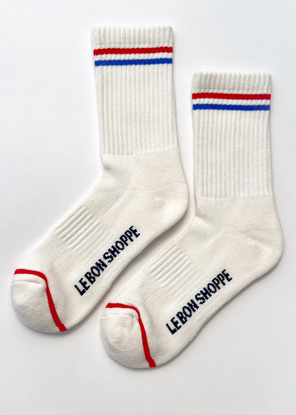 White socks with red and blue stripes and 'LEBON SHOPPE' branding on a white background