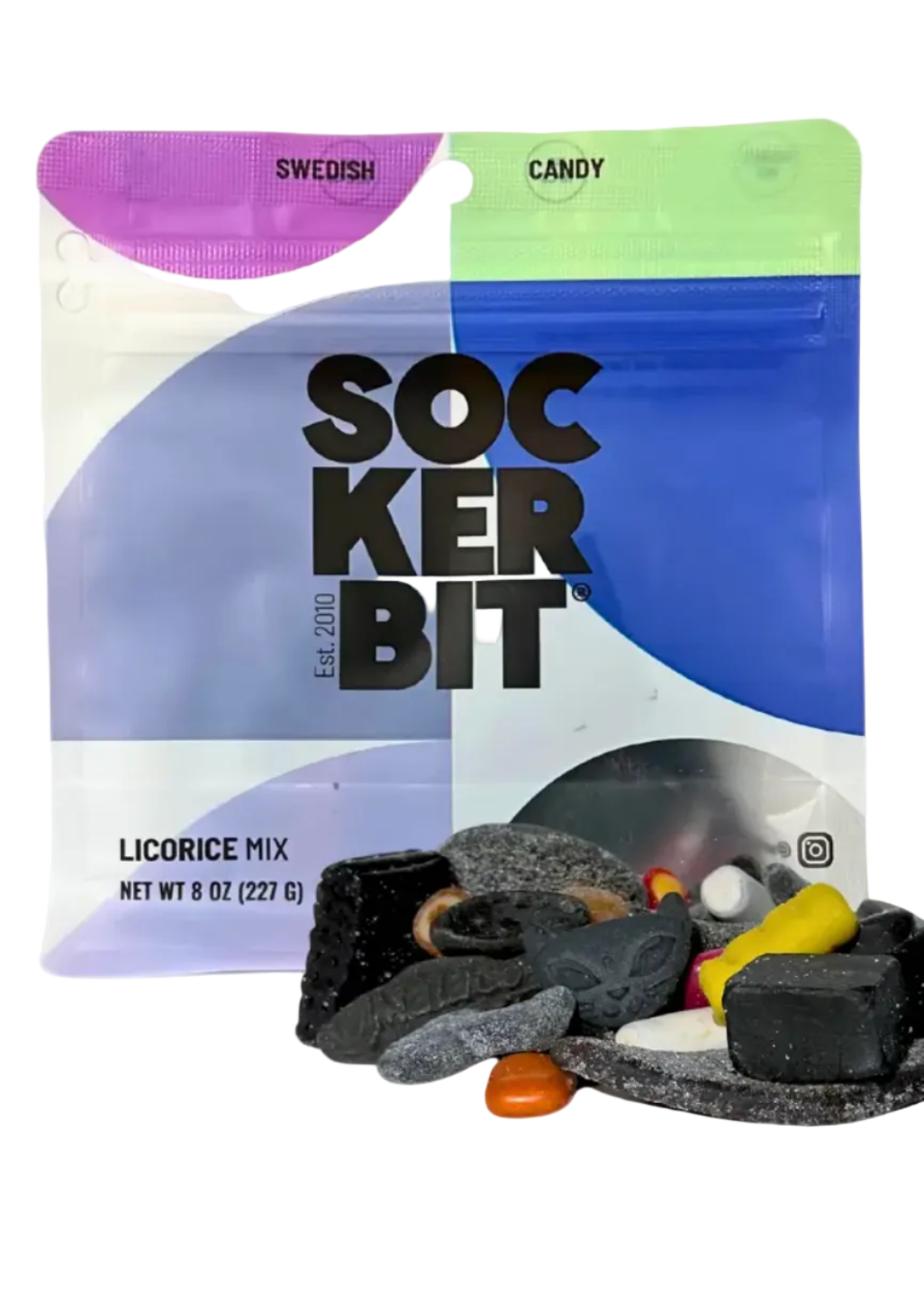 A stand-up pouch of Sockerbit Swedish Candy licorice mix with several assorted licorice candies placed in front on a plain light background. The package is white, blue, and purple with large black 'SOCKERBIT' text, and the candies are mostly black with some yellow, orange, and gray visible.