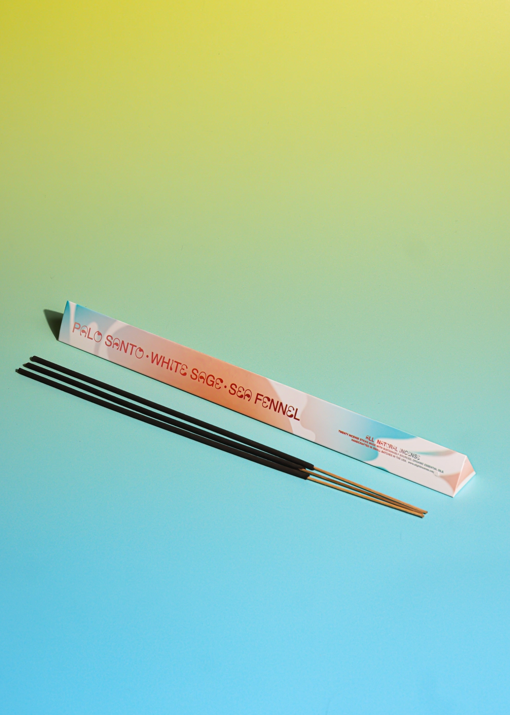 3 sticks of incense and packaging against a green and blue background