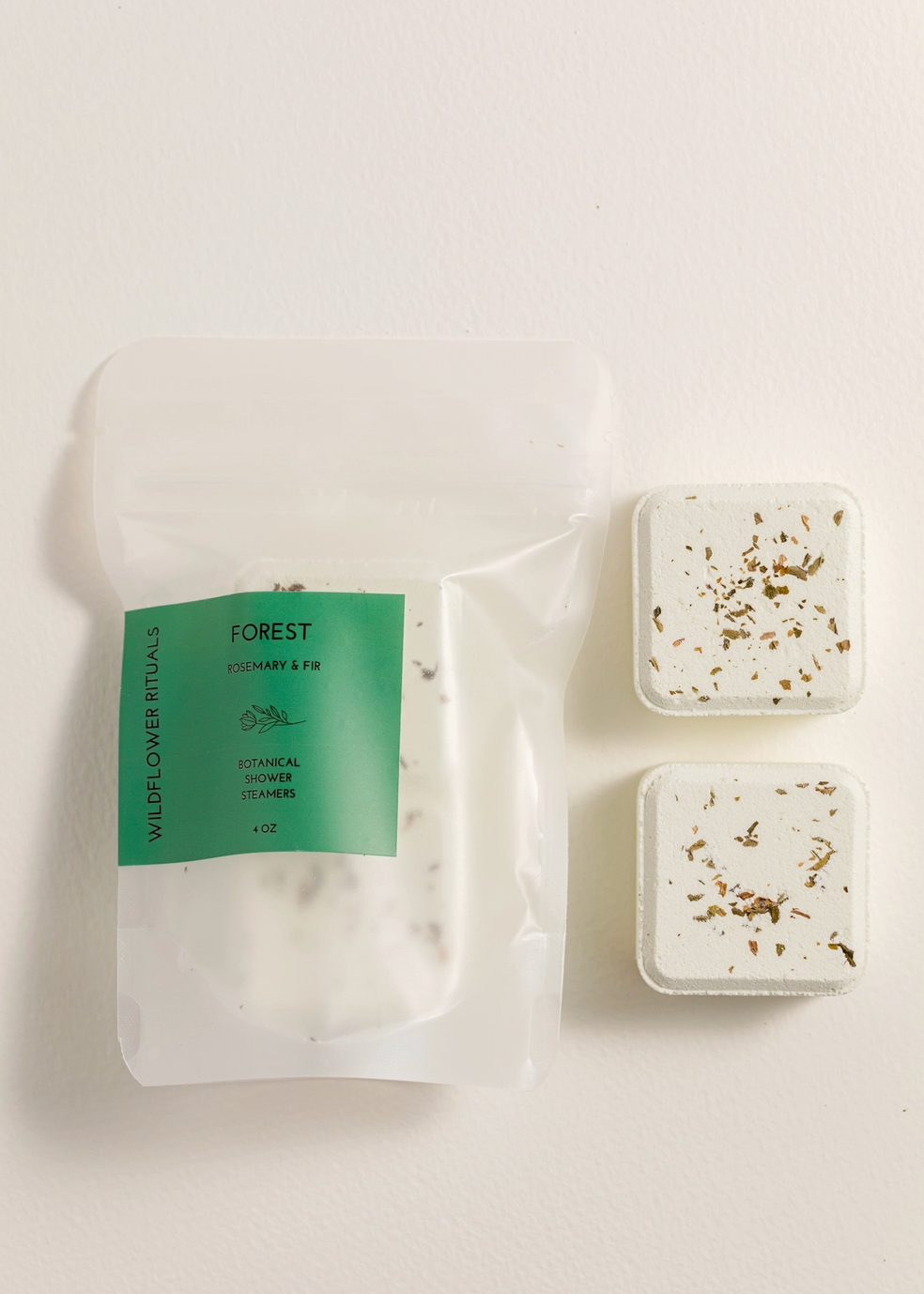 shower steamers next to clear bag with green label