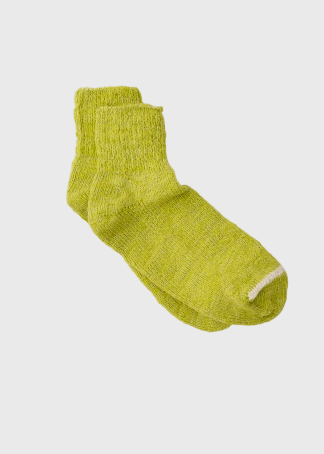 A pair of textured lime green crew socks with a contrasting white tip, laid flat on a light beige background.