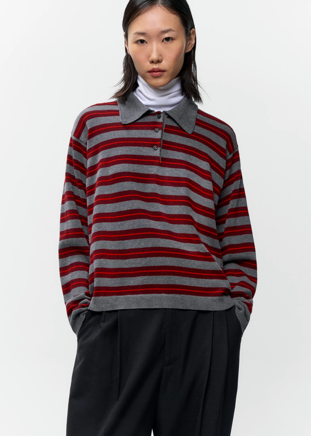 grey and red striped polo on model wearing black pants 