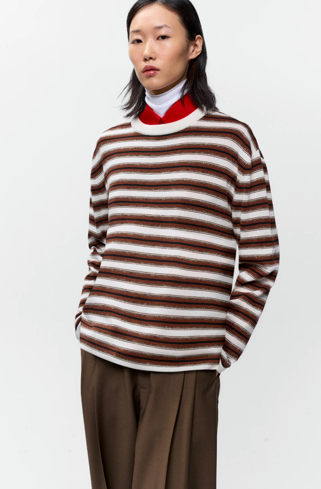 brown, black and white striped long sleeve t shirt on model with brown pants
