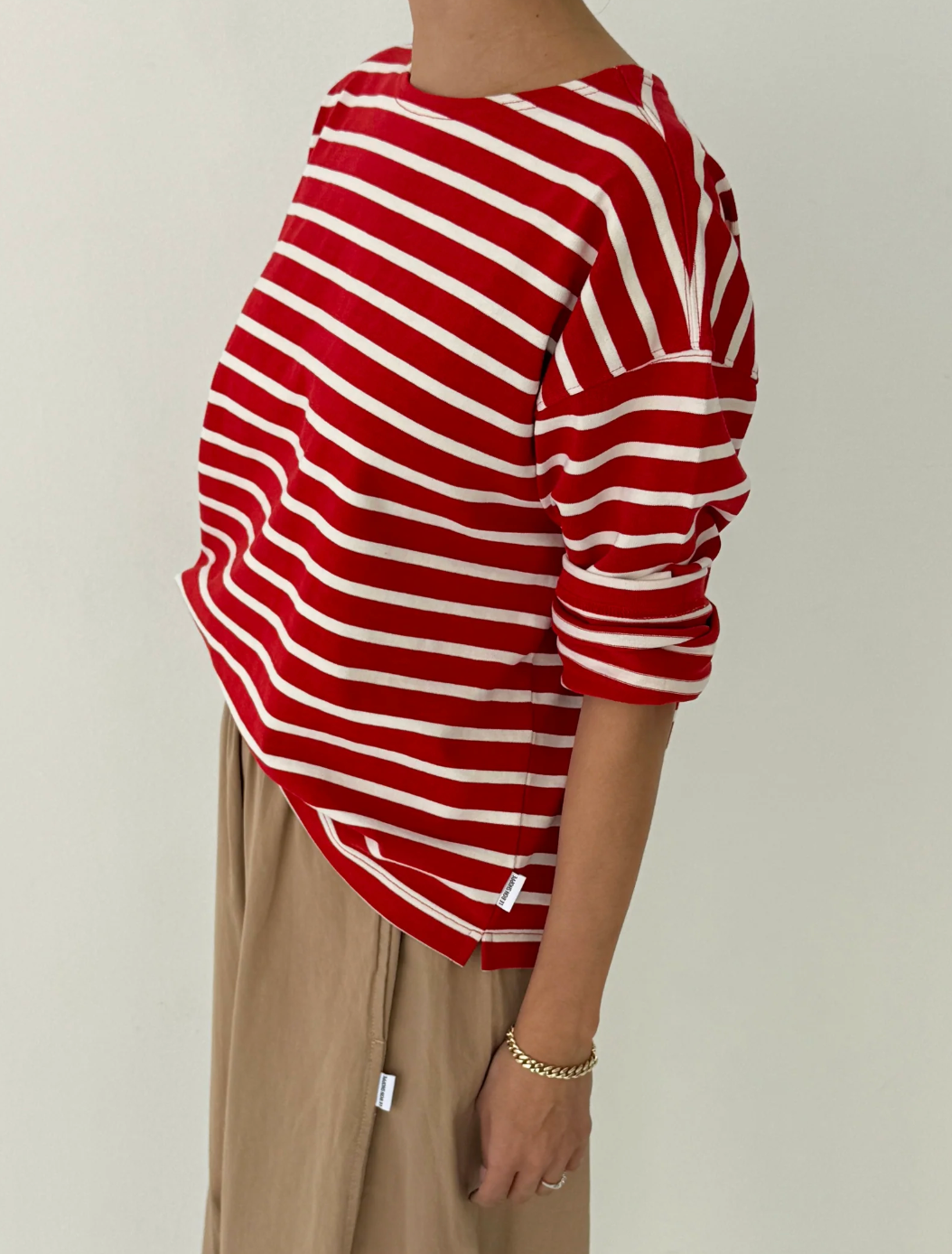 Red and white striped shirt worn by a person on a plain background