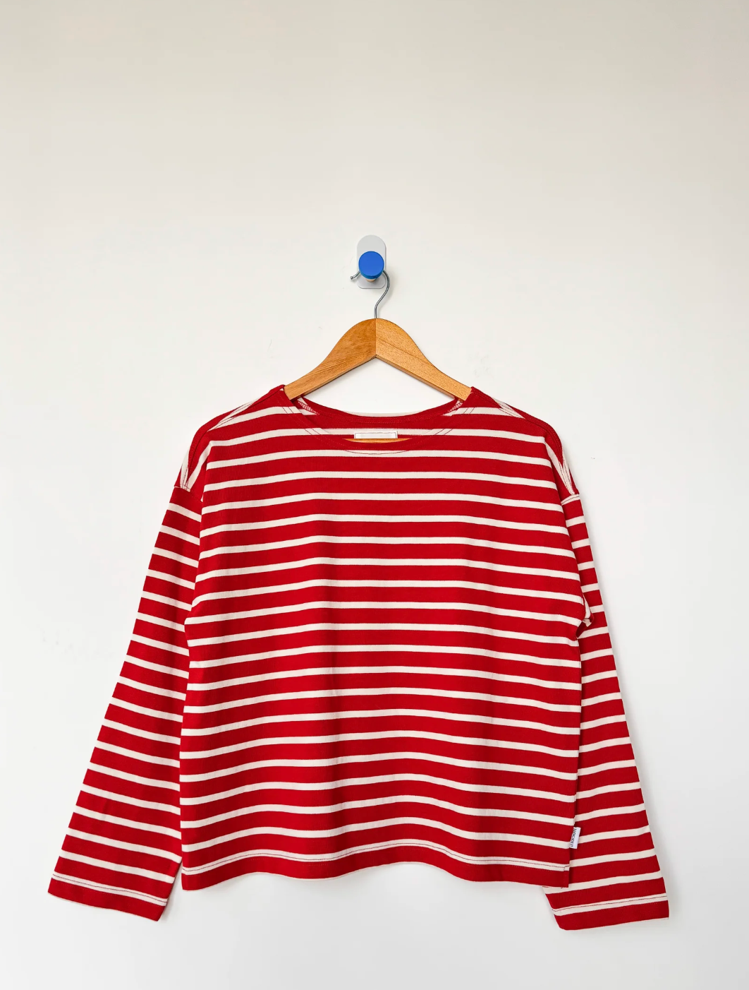 Red and white striped shirt on a hanger against a white background