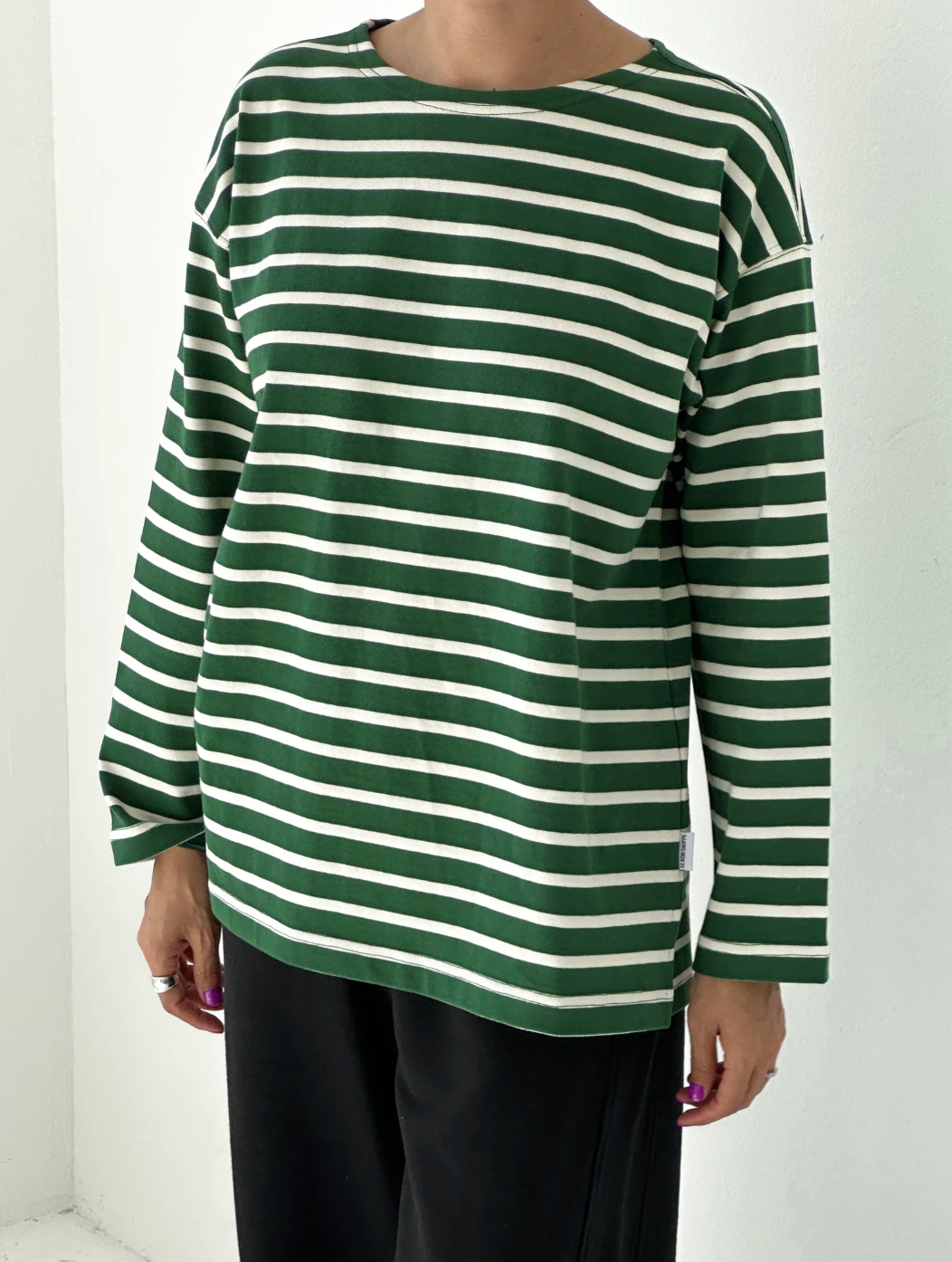 Green and white striped long-sleeve shirt worn by a person on a white background