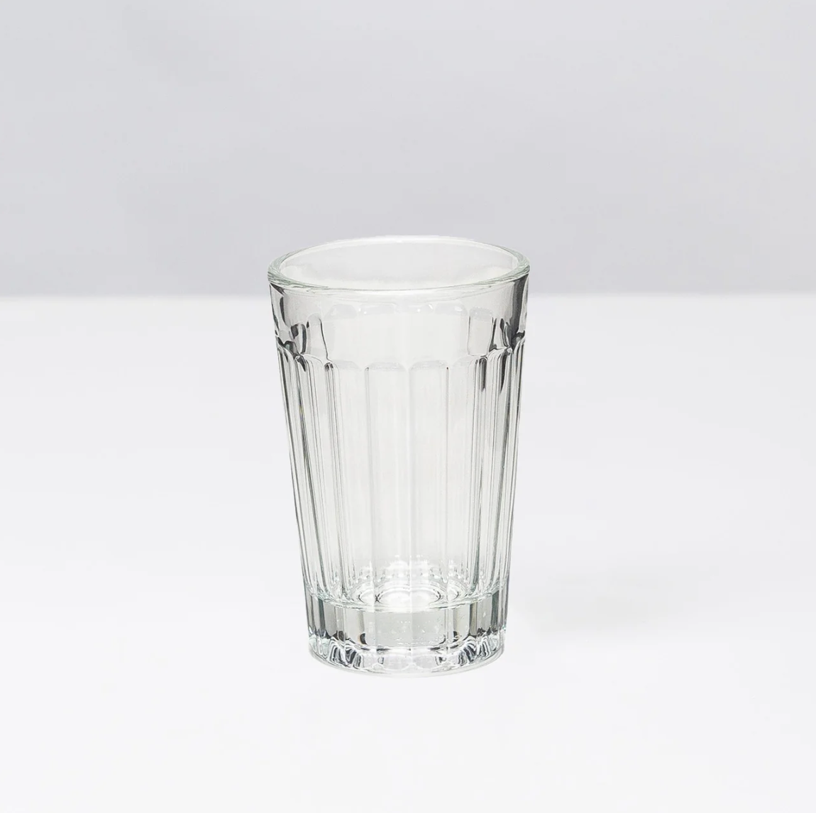 Clear glass tumbler on a light gray background