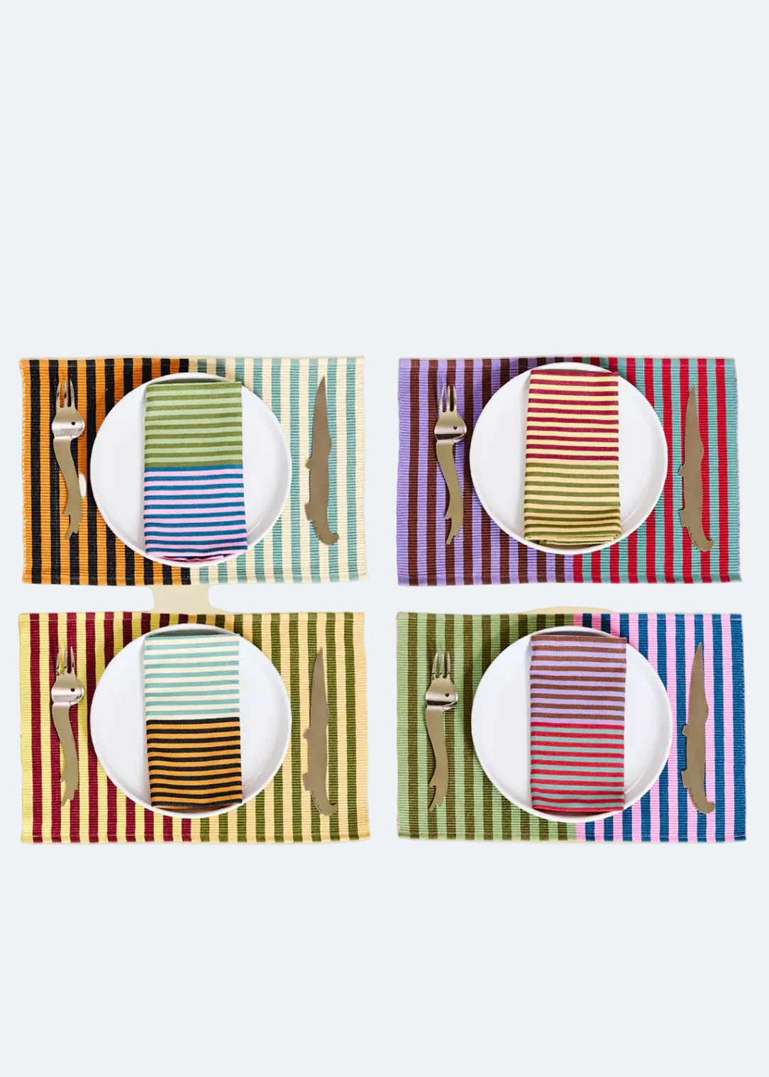 Four colorful striped placemats with plates, cutlery, and napkins