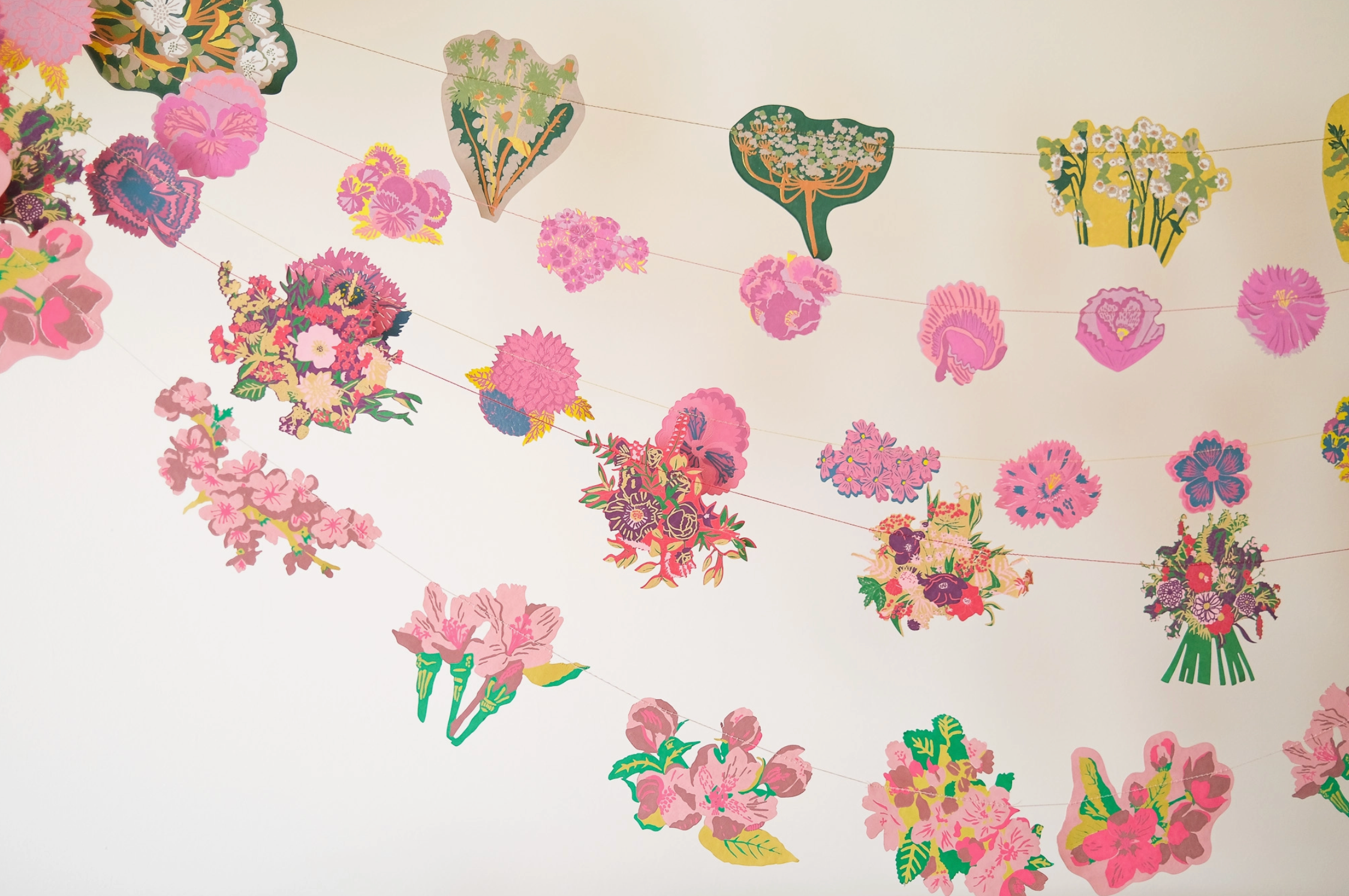 Decorative paper cutouts of flowers and abstract shapes on a white background