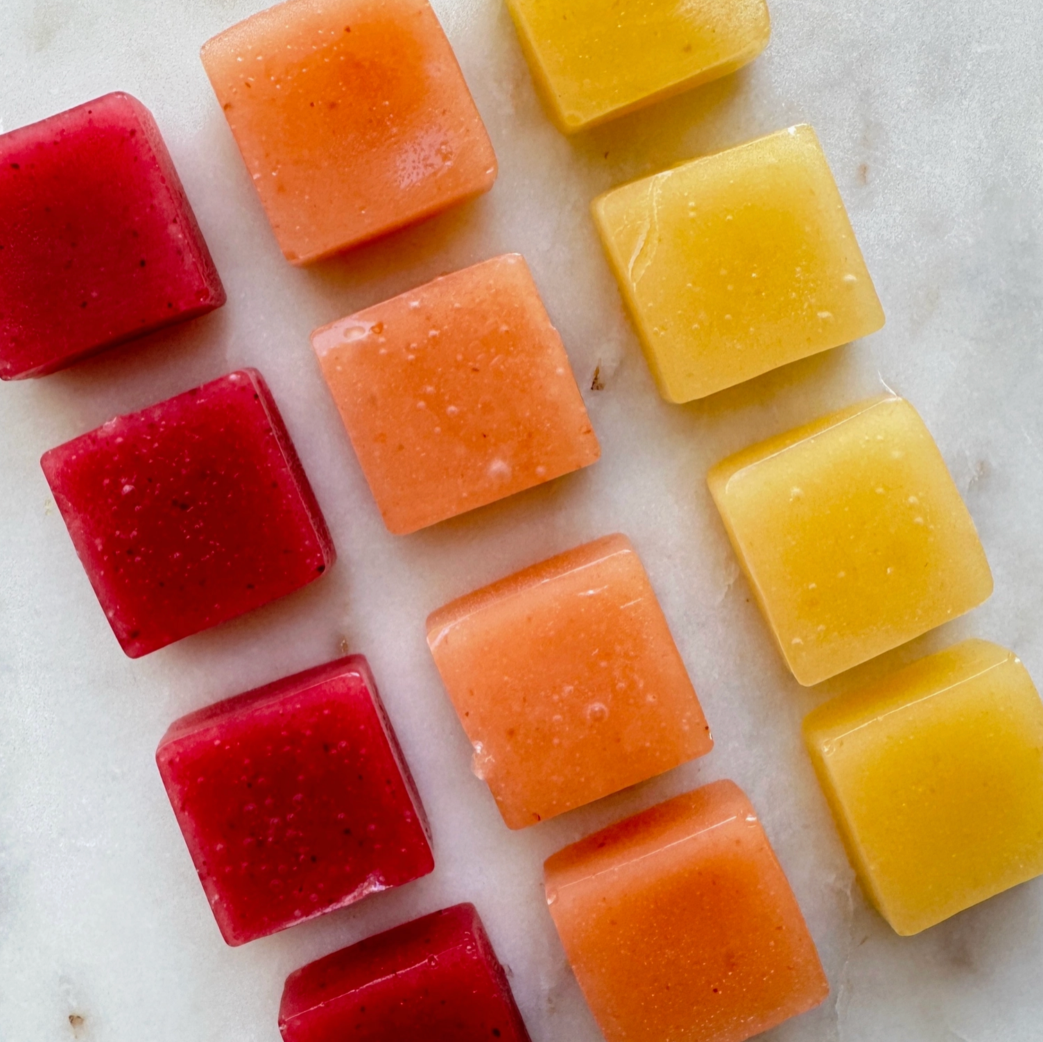 Colorful square fruit cubes on a marble surface