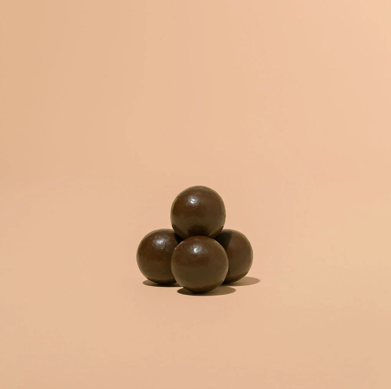 Three dark brown spheres on a beige background