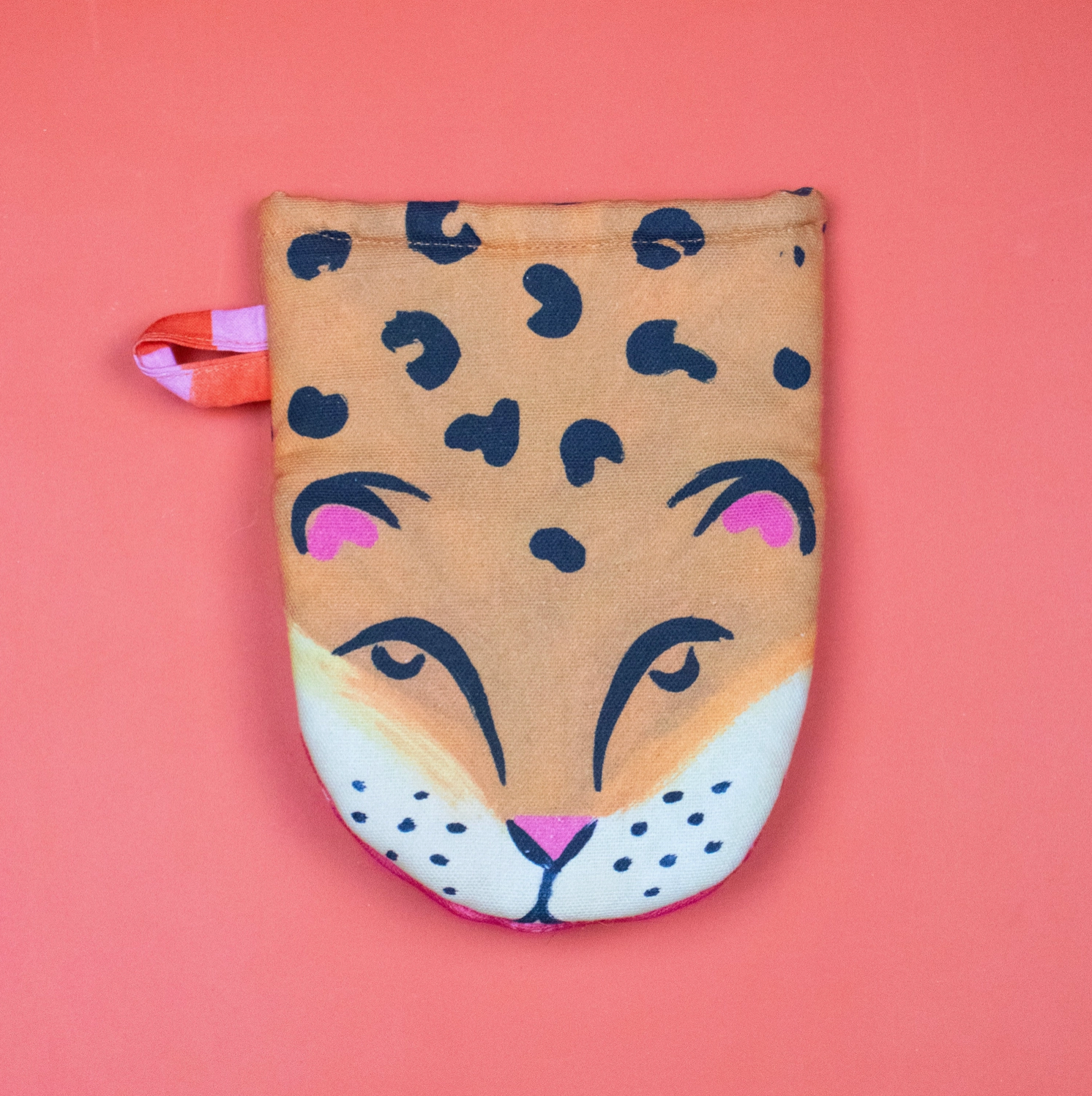 Leopard print oven mitt on a pink background