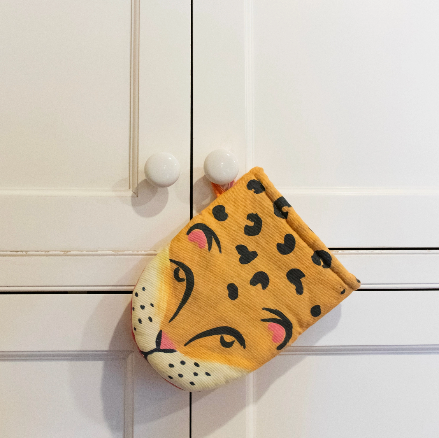Leopard print pot holder on a white cabinet