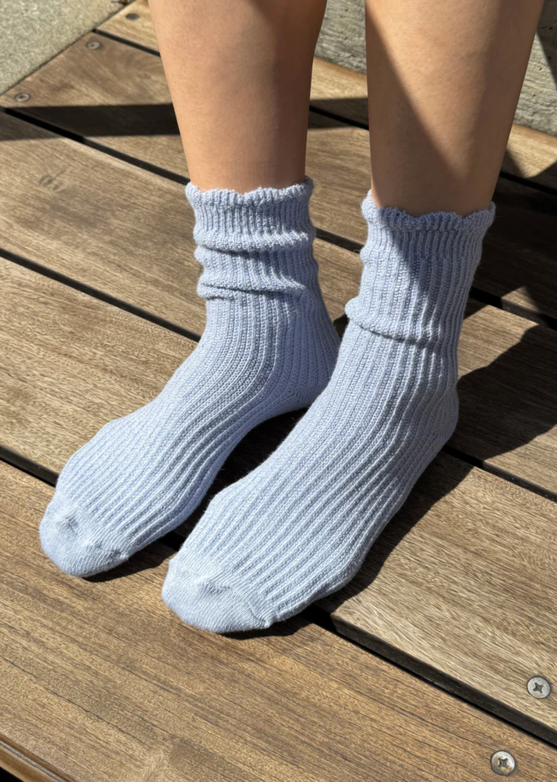 Light blue socks worn on a wooden floor