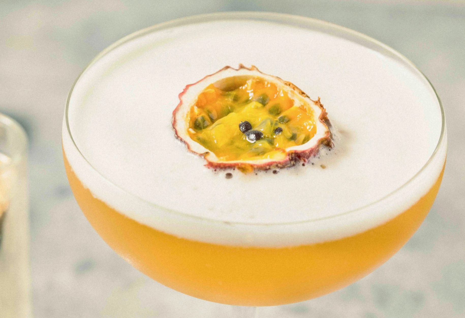 yellow drink with foam and passionfruit