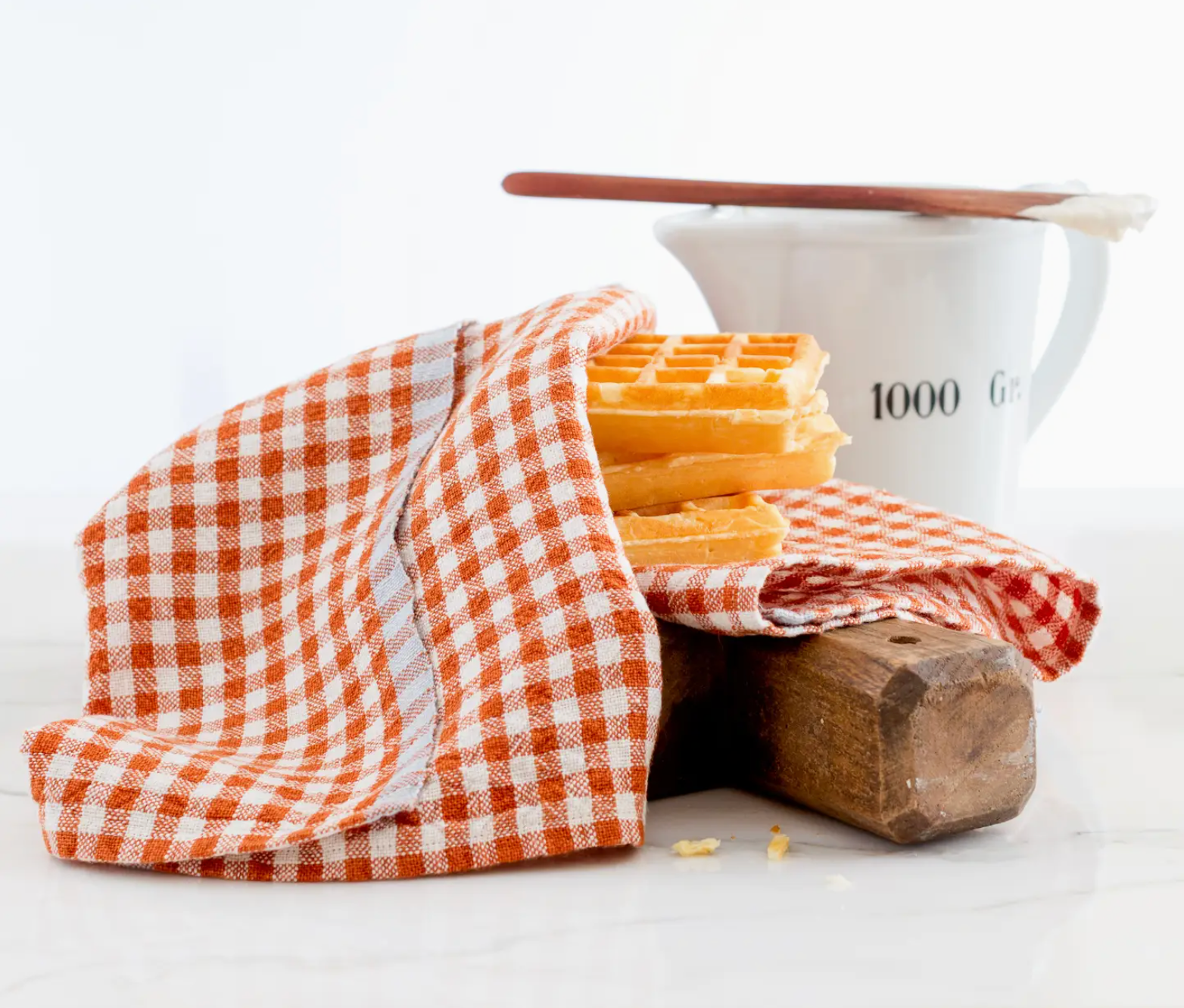 gingham napkins with waffles and cooking utensils
