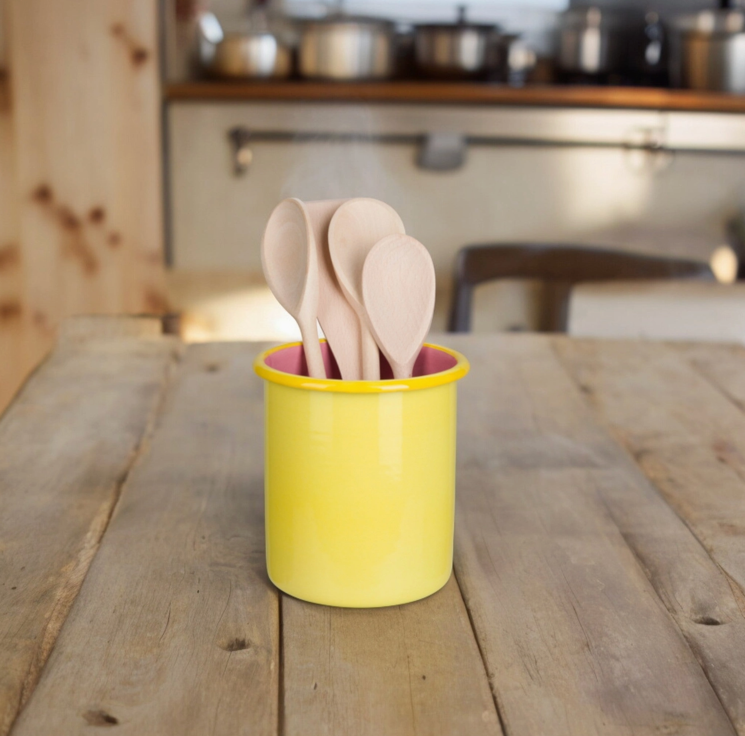 kitchen scene with wooden table and yellow holder with wooden utensils