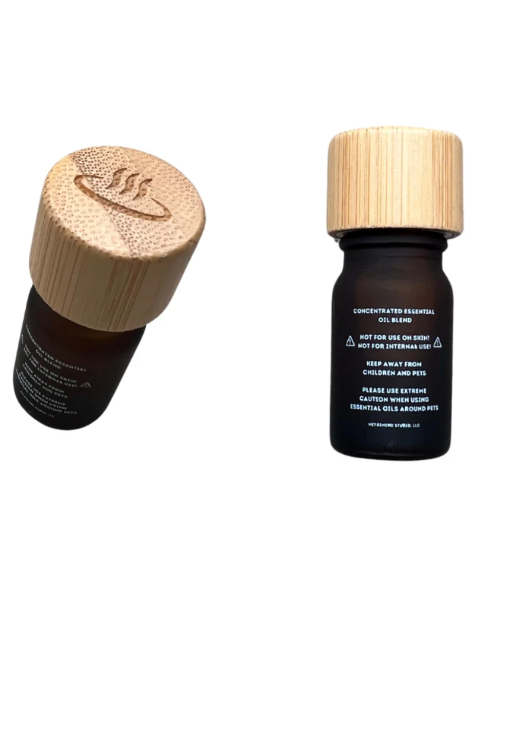 Two small essential oil bottles on a plain white background