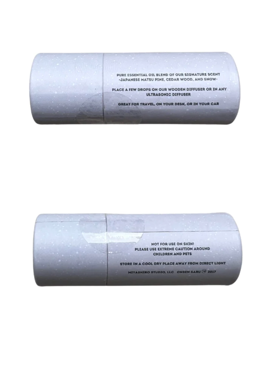 Two cylindrical bottles shown vertically on a plain white background, one above the other. The bottles are light gray with black printed text detailing the scent and care instructions.