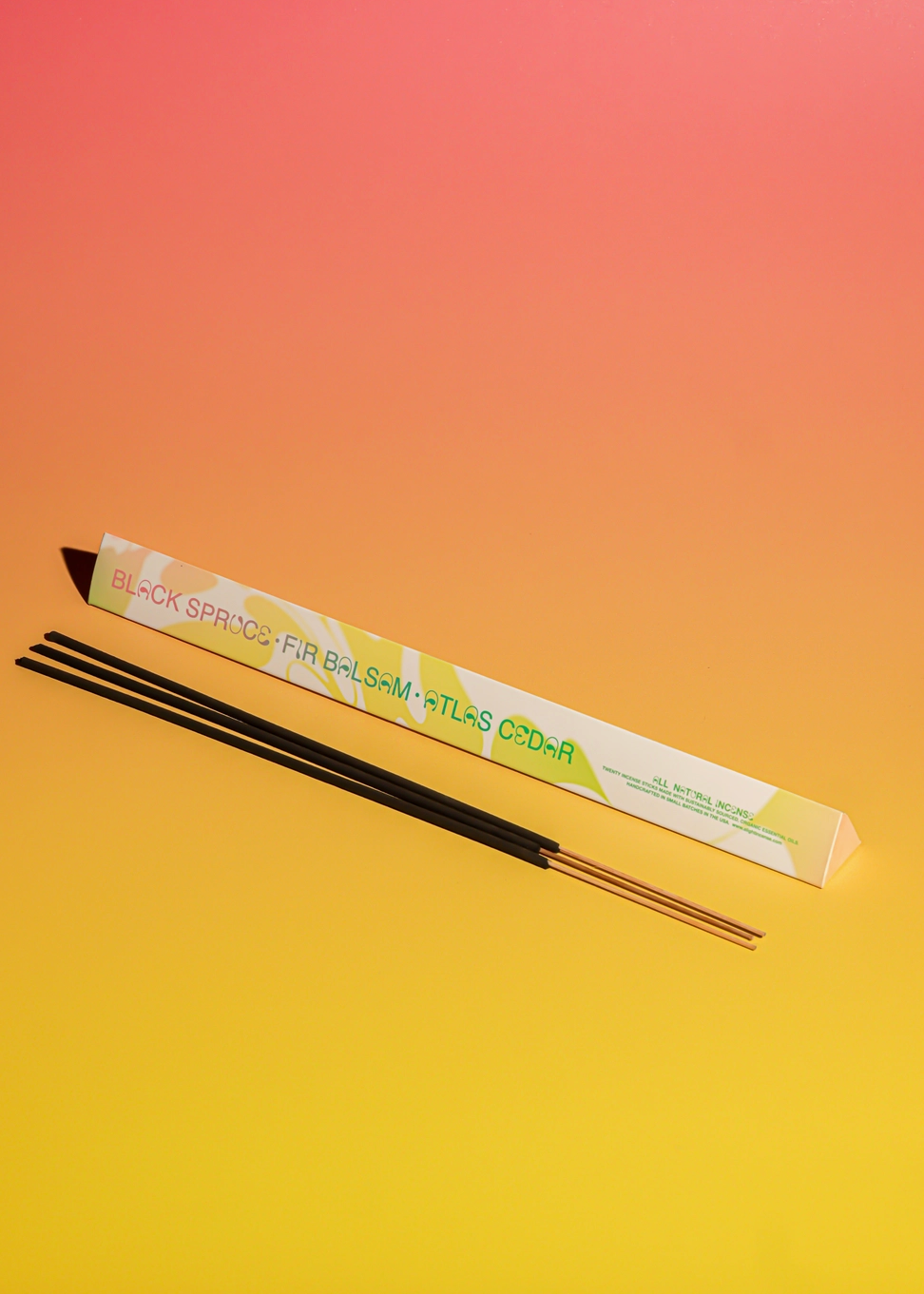 incense sticks and packaging on a peach and yellow background