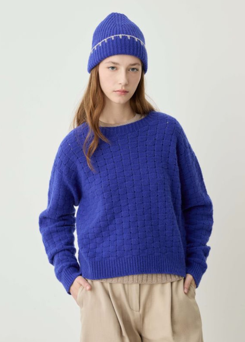 blue sweater on model wearing hat and tan pants