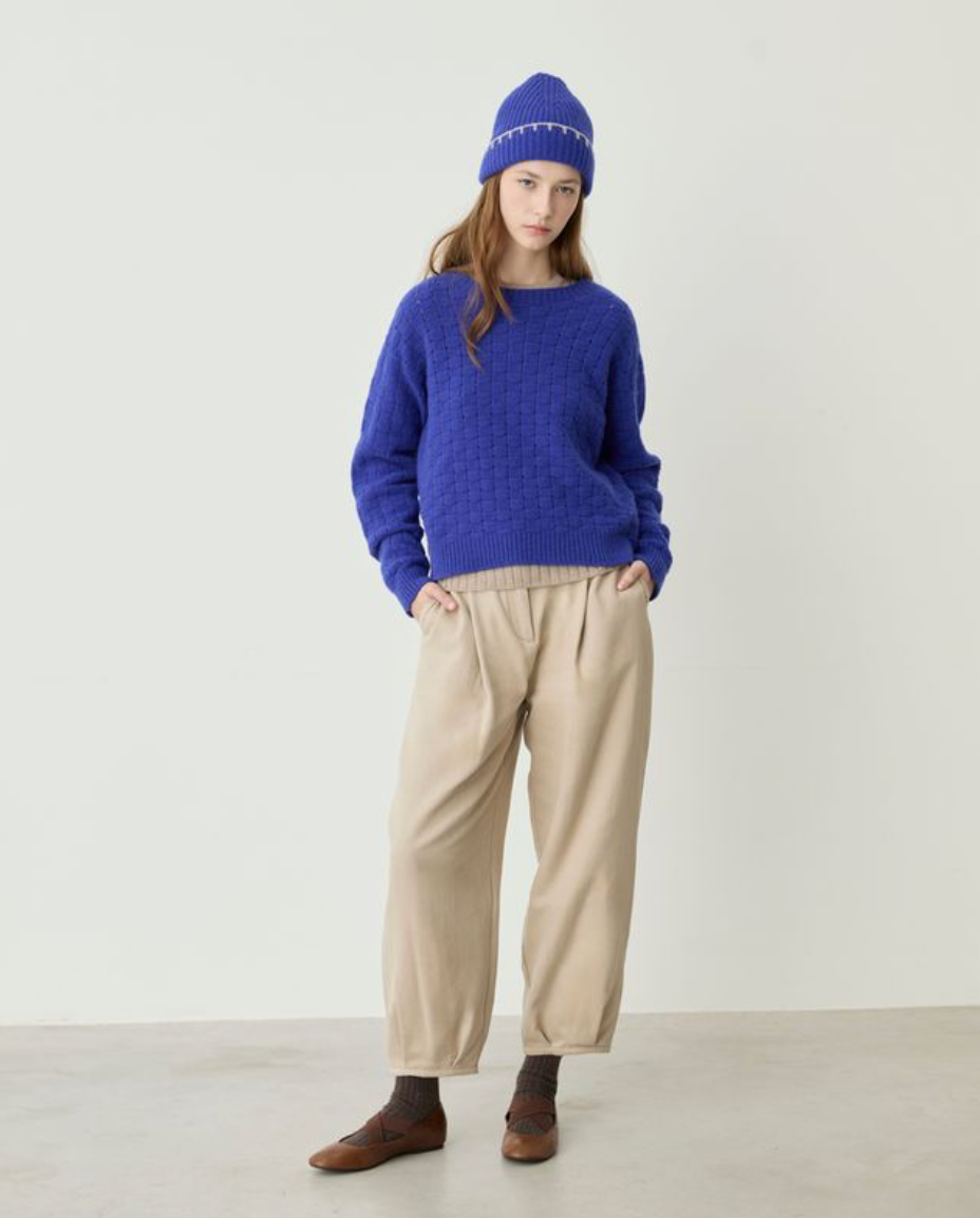 blue sweater on model wearing hat and tan pants