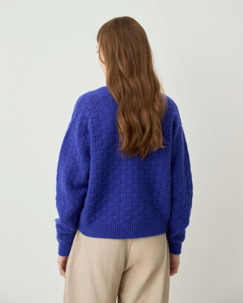 blue sweater on model with tan pants